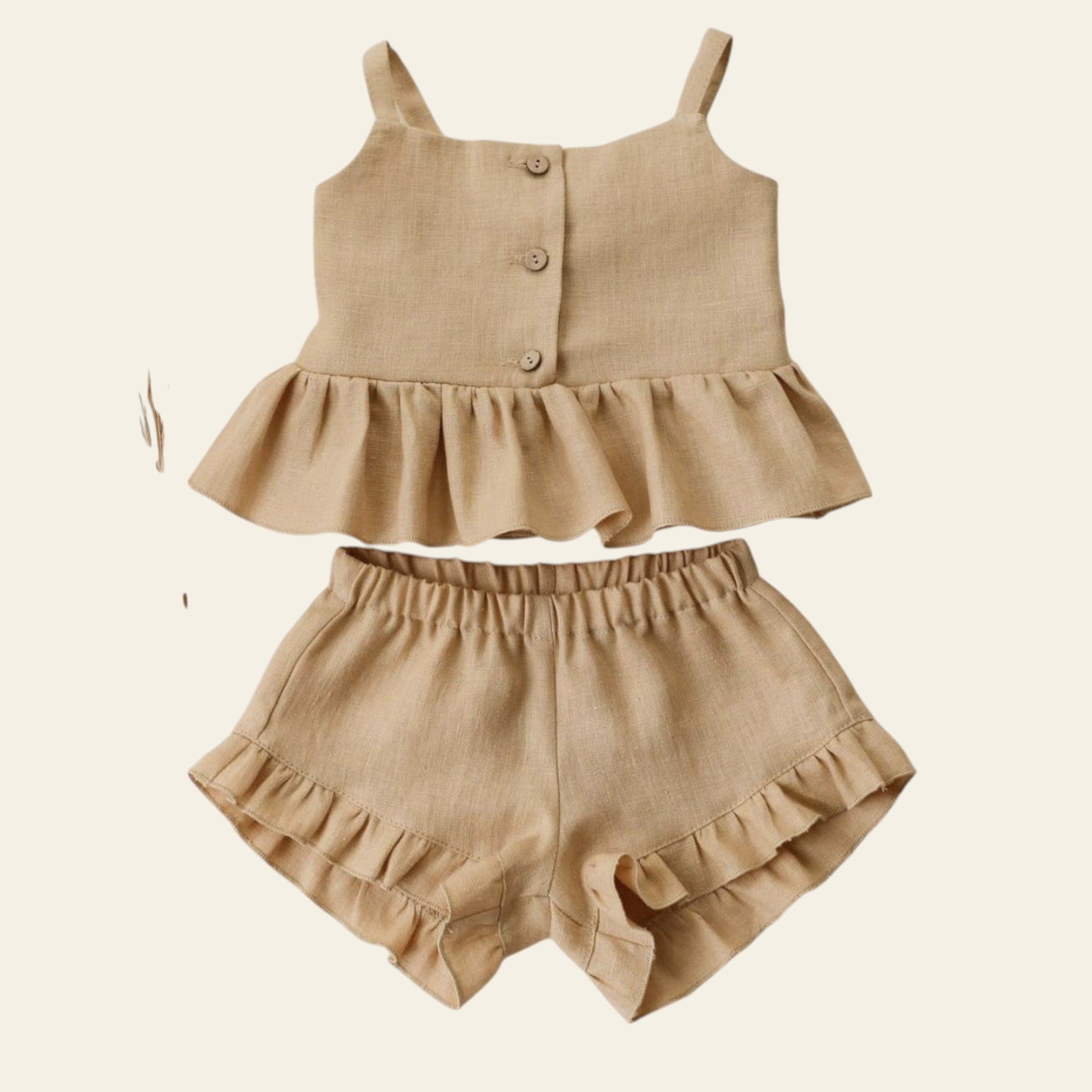 Beige ruffled top and shorts set on a light background with dried flowers.