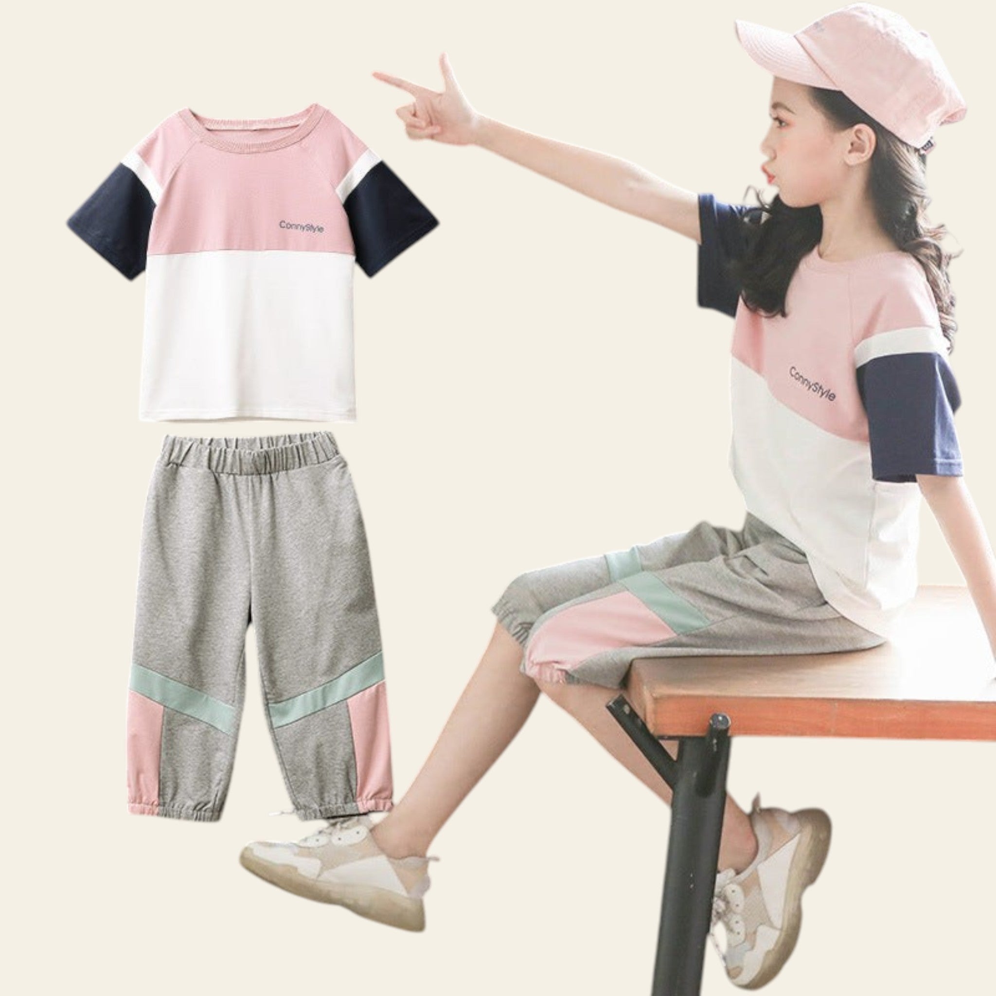 Child wearing a matching outfit with a pink and white top and gray pants, sitting on a chair.