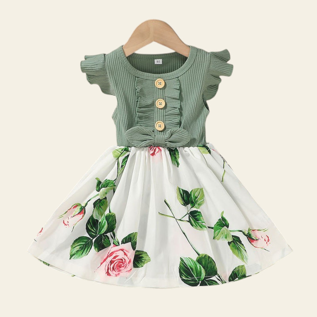 Green top and floral skirt set on a beige background with 'BABY' letters.