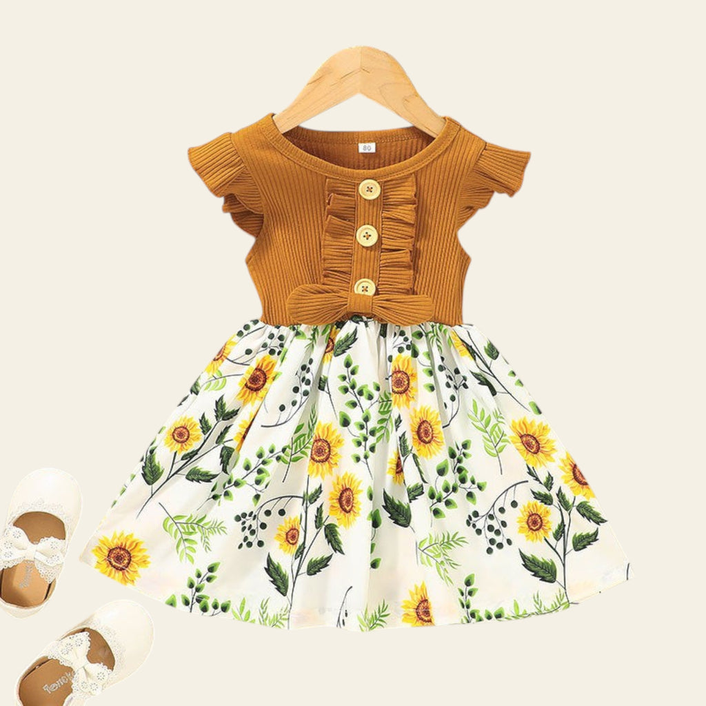 Children's outfit with mustard top and sunflower print skirt on a beige background