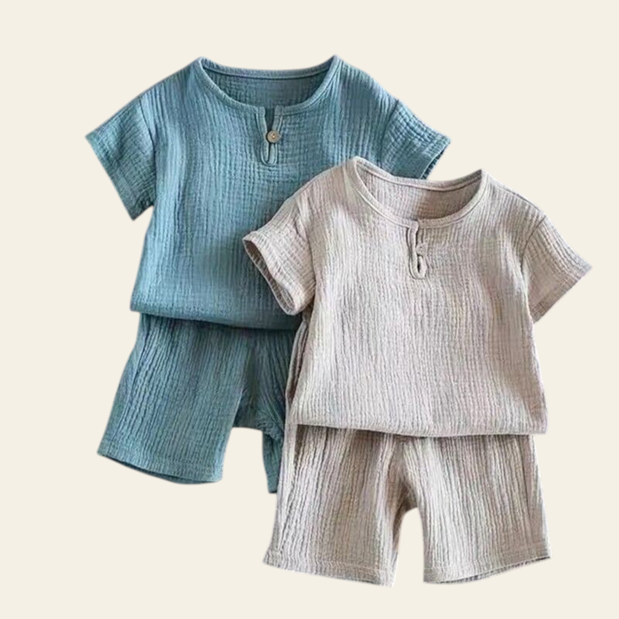 Two children's outfits, one blue and one beige, on a gray background.