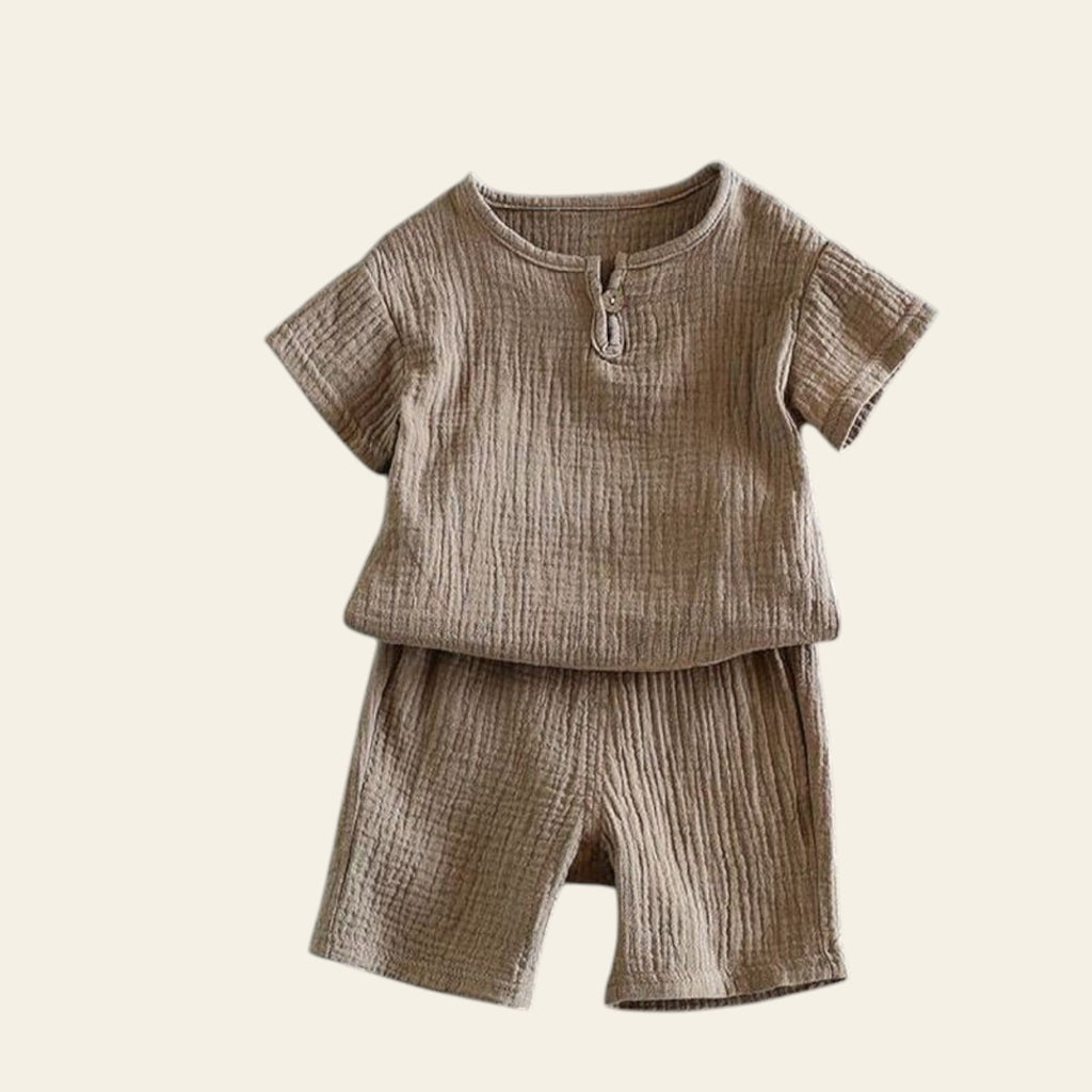 Brown textured shirt and shorts set on a gray background with a plant.