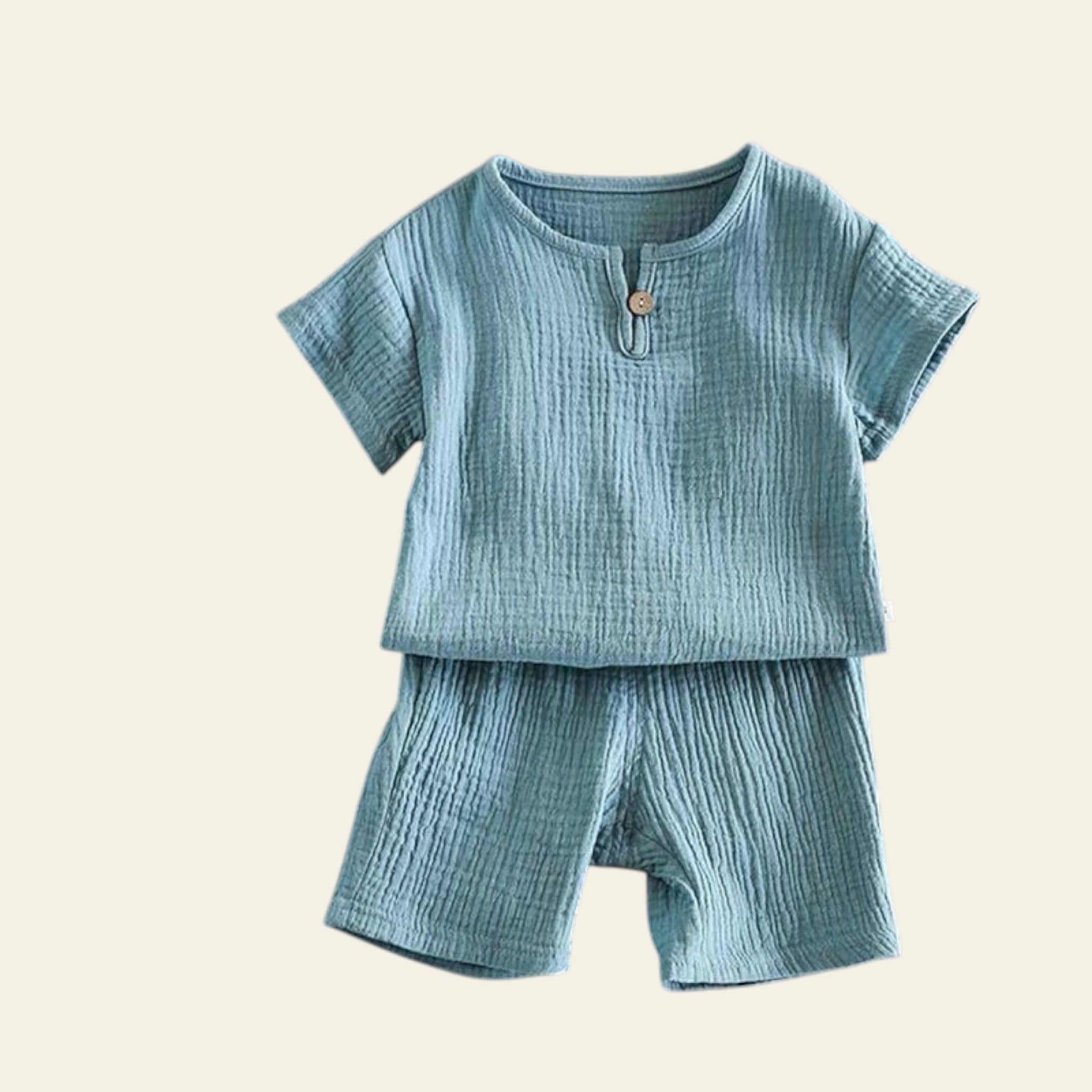 Children's teal outfit with top and shorts on a gray background