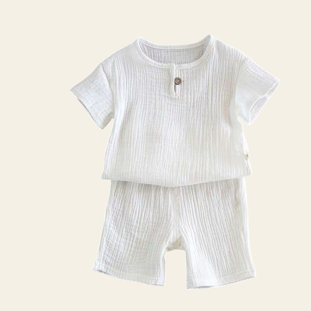 White baby outfit with shirt and shorts on a gray background