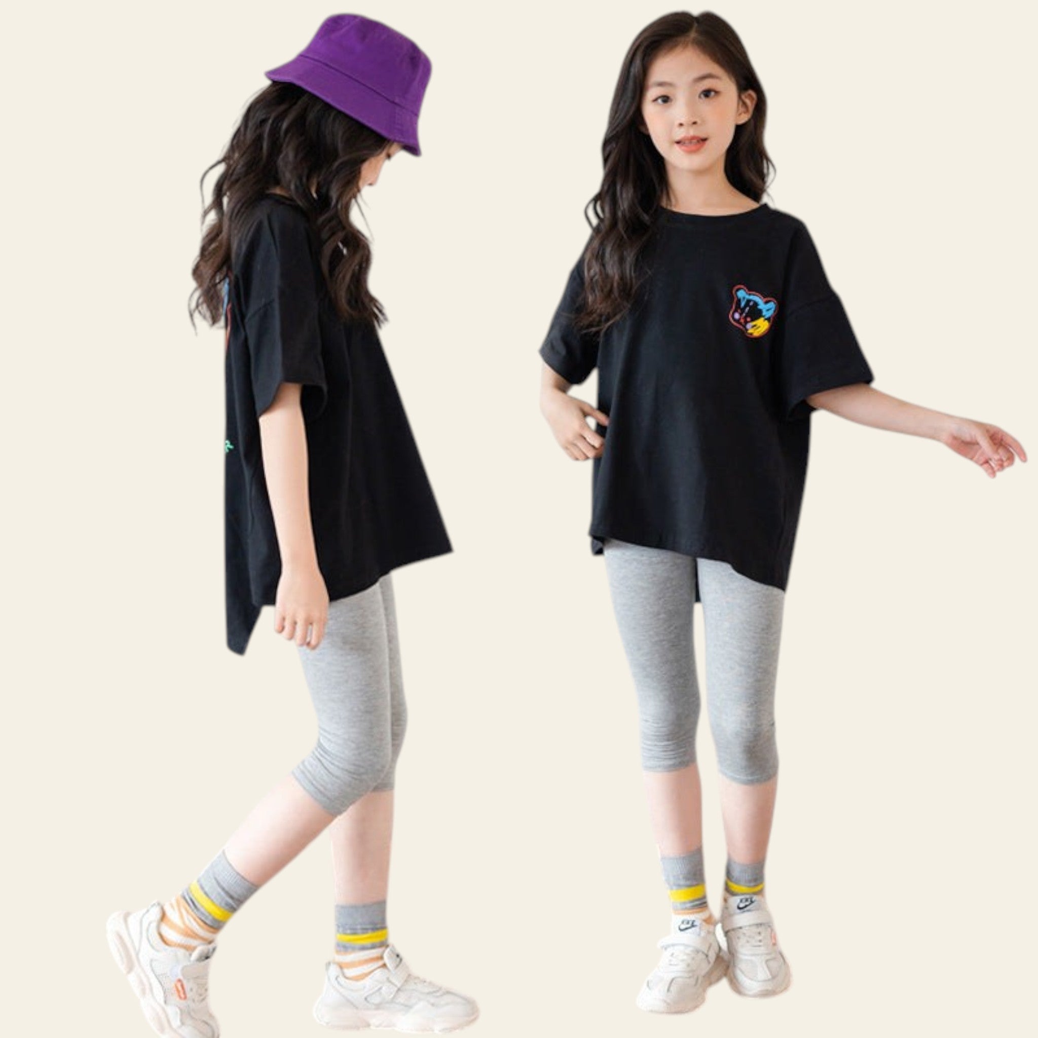 Two children wearing black t-shirts, gray leggings, and white sneakers on a wooden floor.