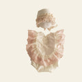 Baby outfit with lace details on a beige background