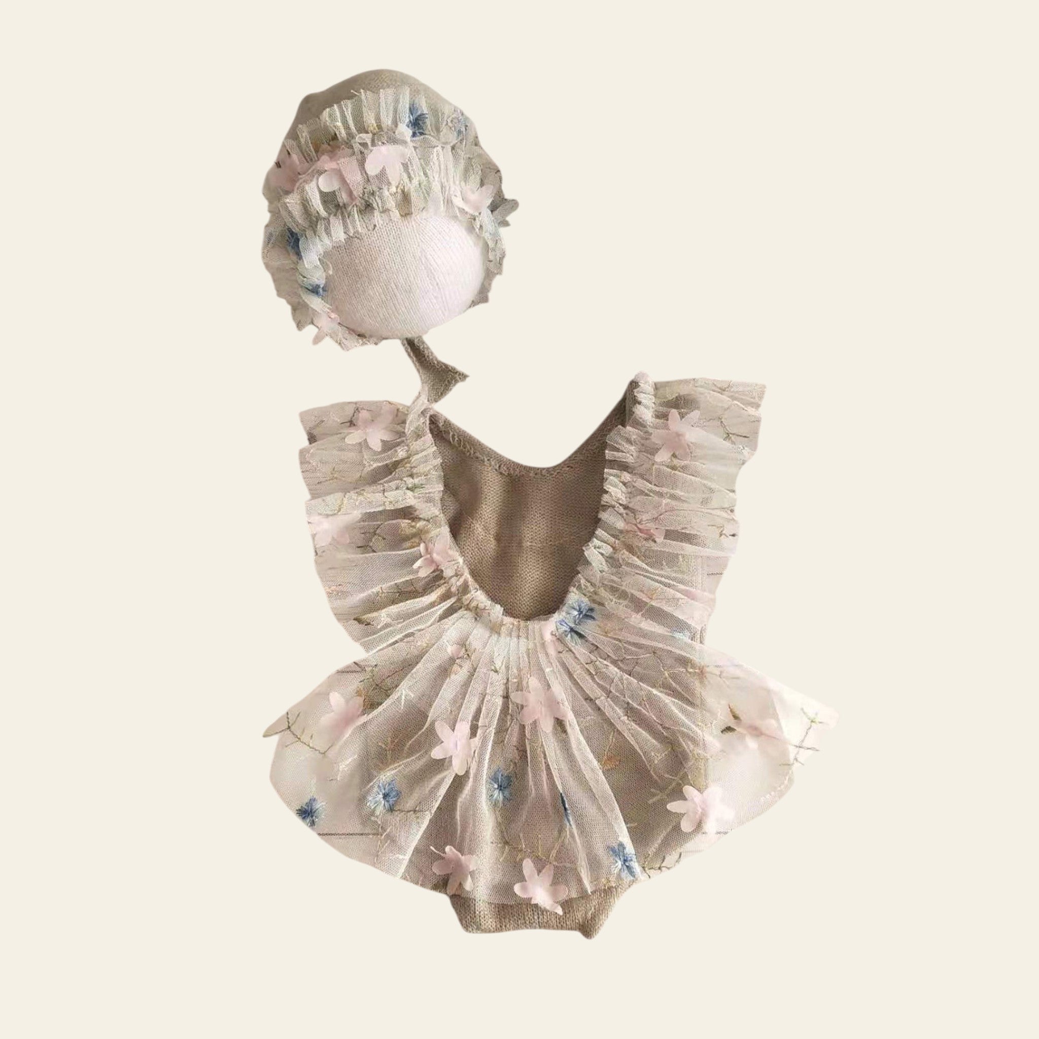 Baby outfit with ruffled dress, headband, and booties on a wooden surface.