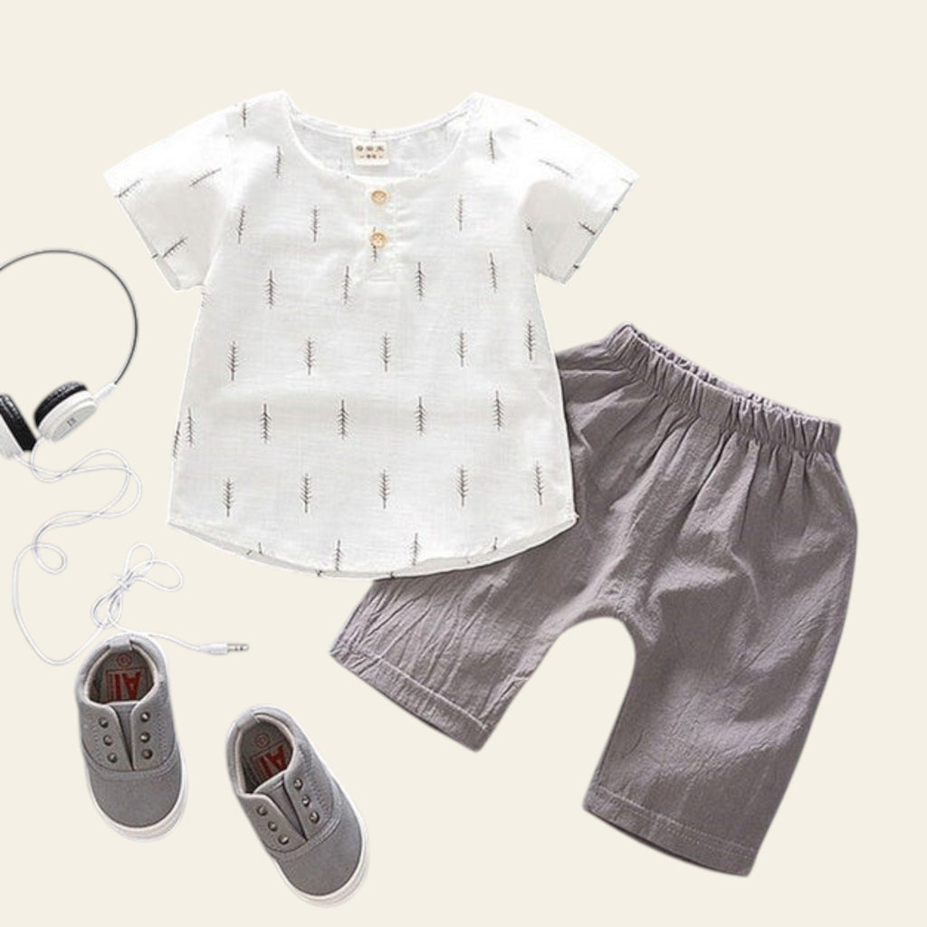 Children's outfit with white shirt, gray shorts, and gray shoes on a light gray background.