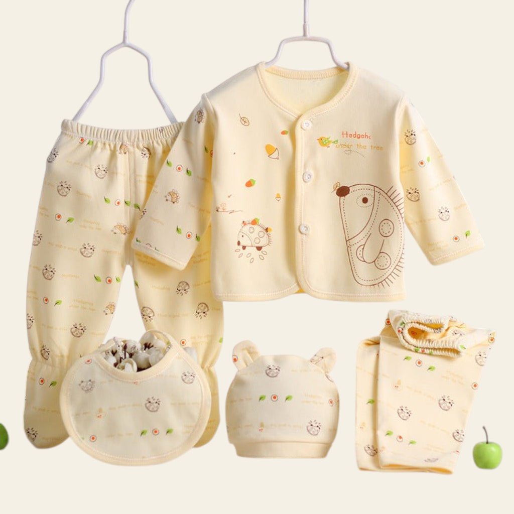Baby clothing set with a jacket, pants, bib, and booties on a white surface.