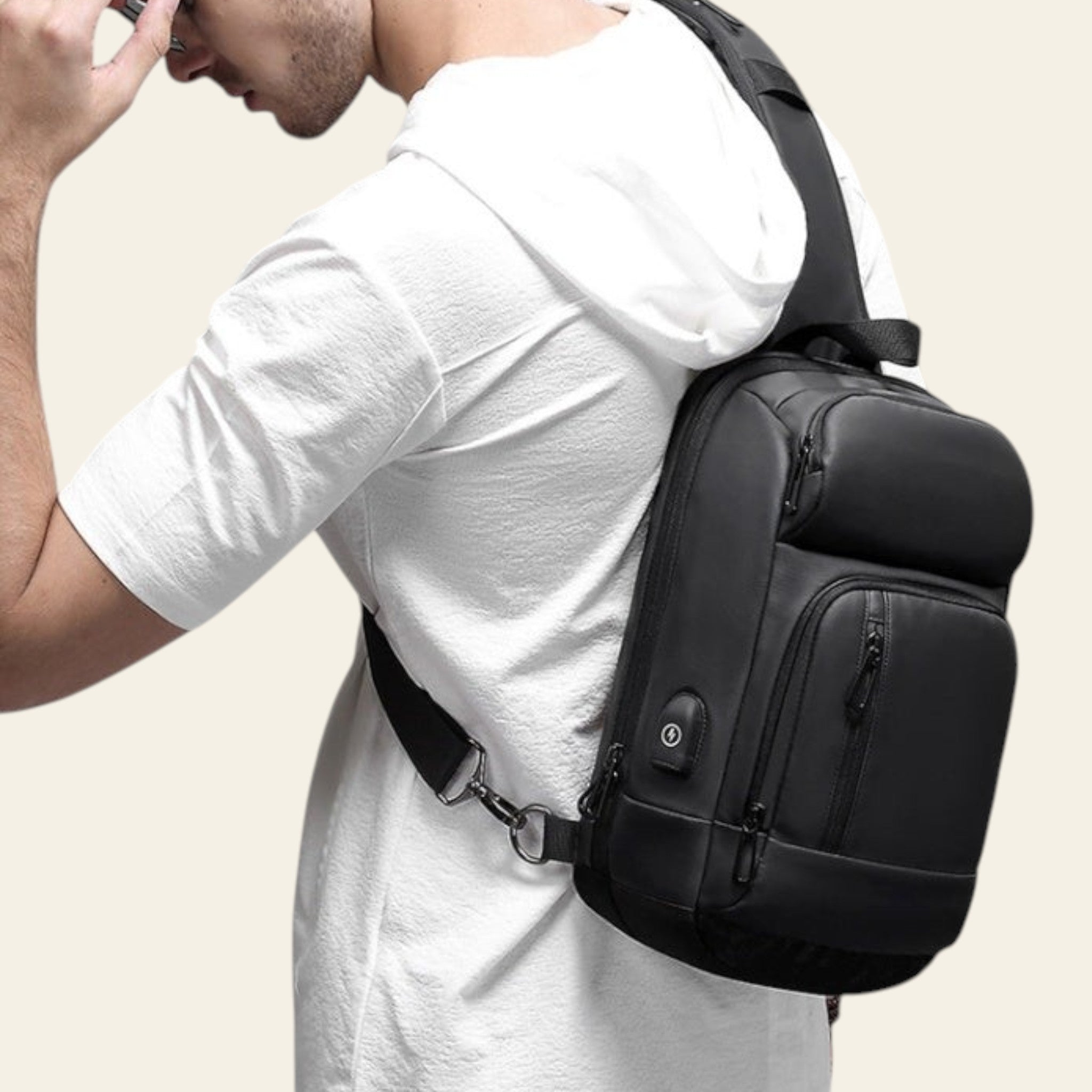 Man wearing a black sling bag on a gray background