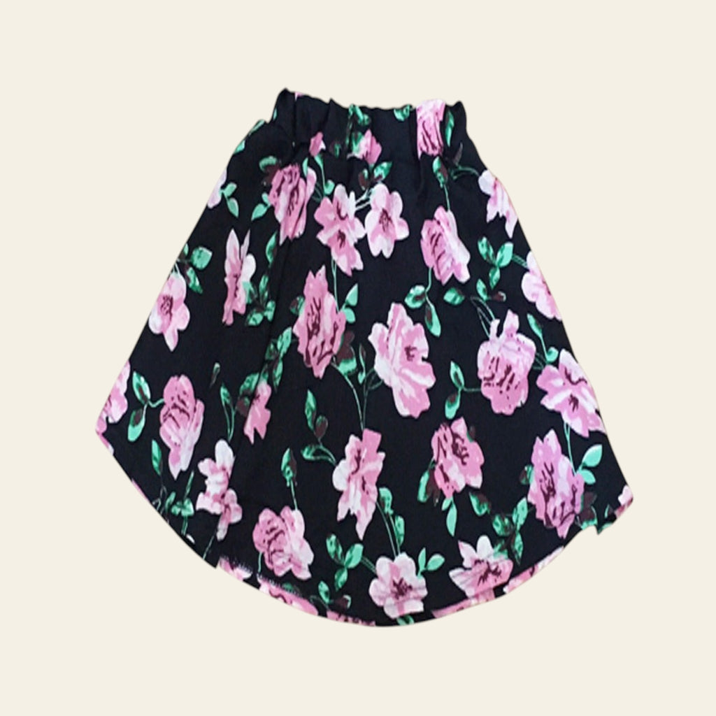 Floral skirt with pink flowers on a black background on a wooden surface