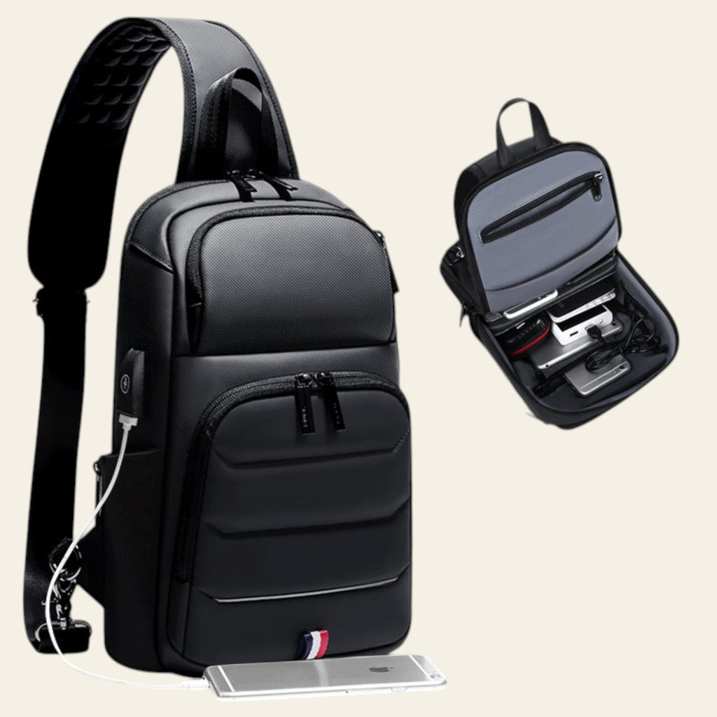 Black sling bag with USB charging port and phone on a gray background