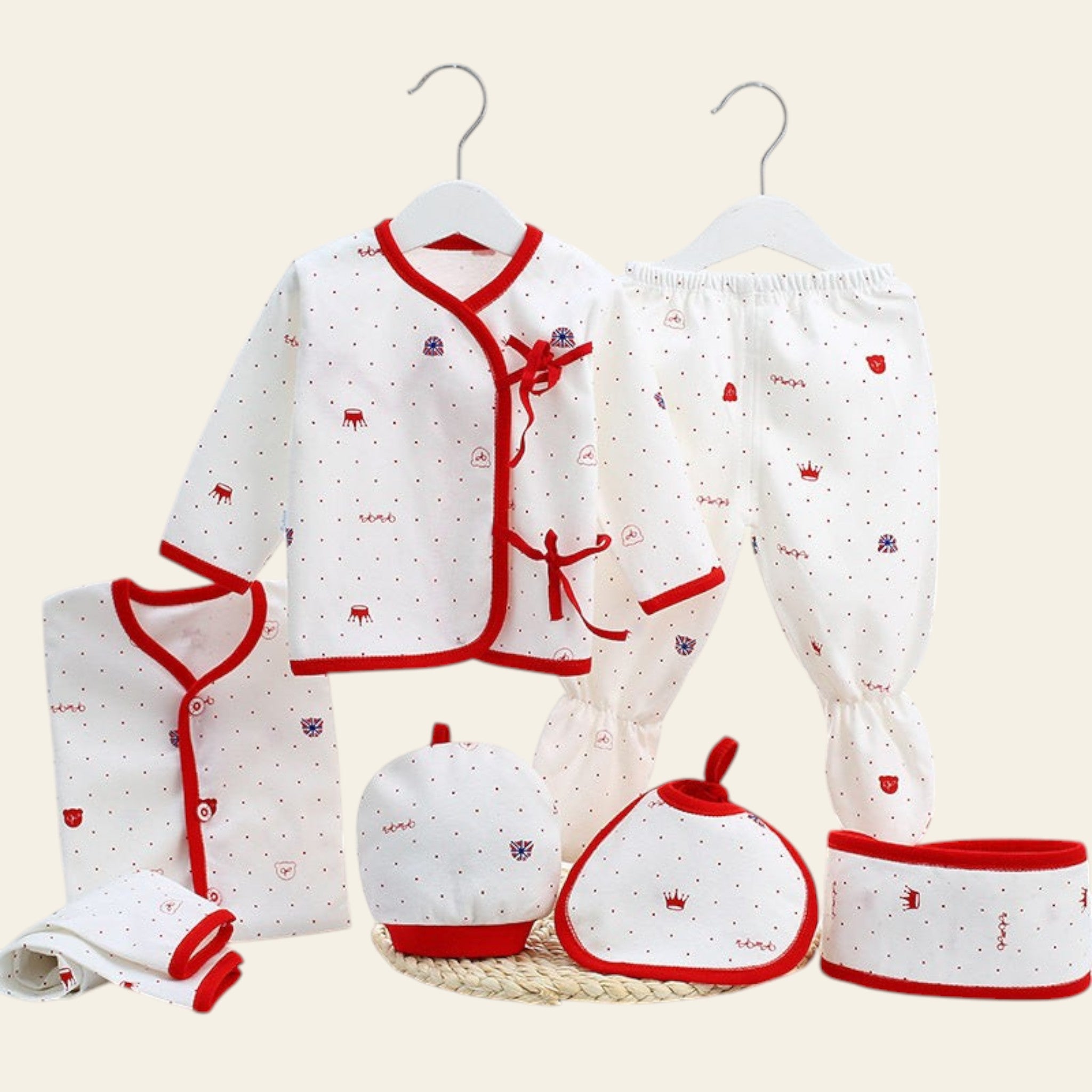 Baby clothing set with red and white patterns on a white surface.
