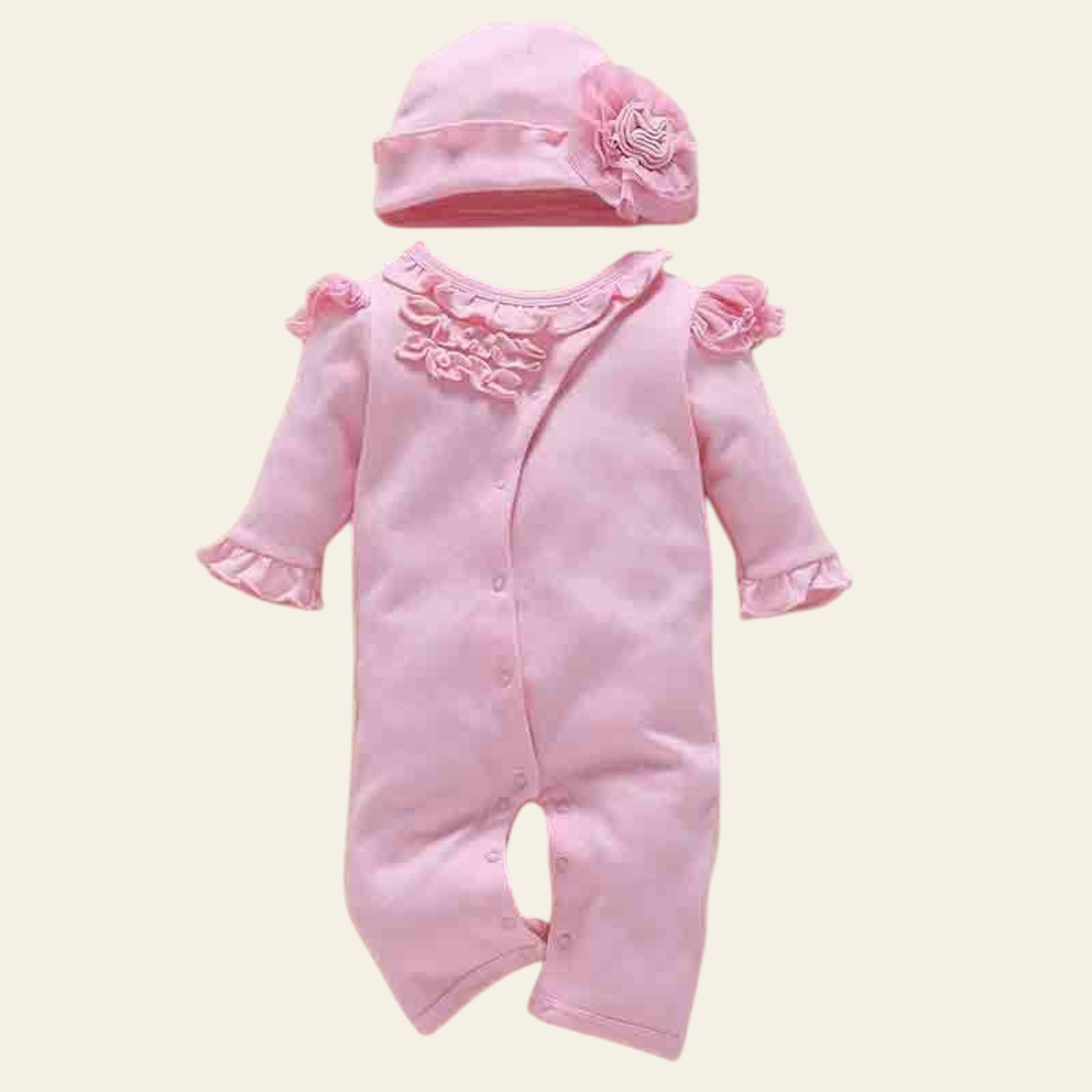 Pink baby romper with matching hat on a beige background