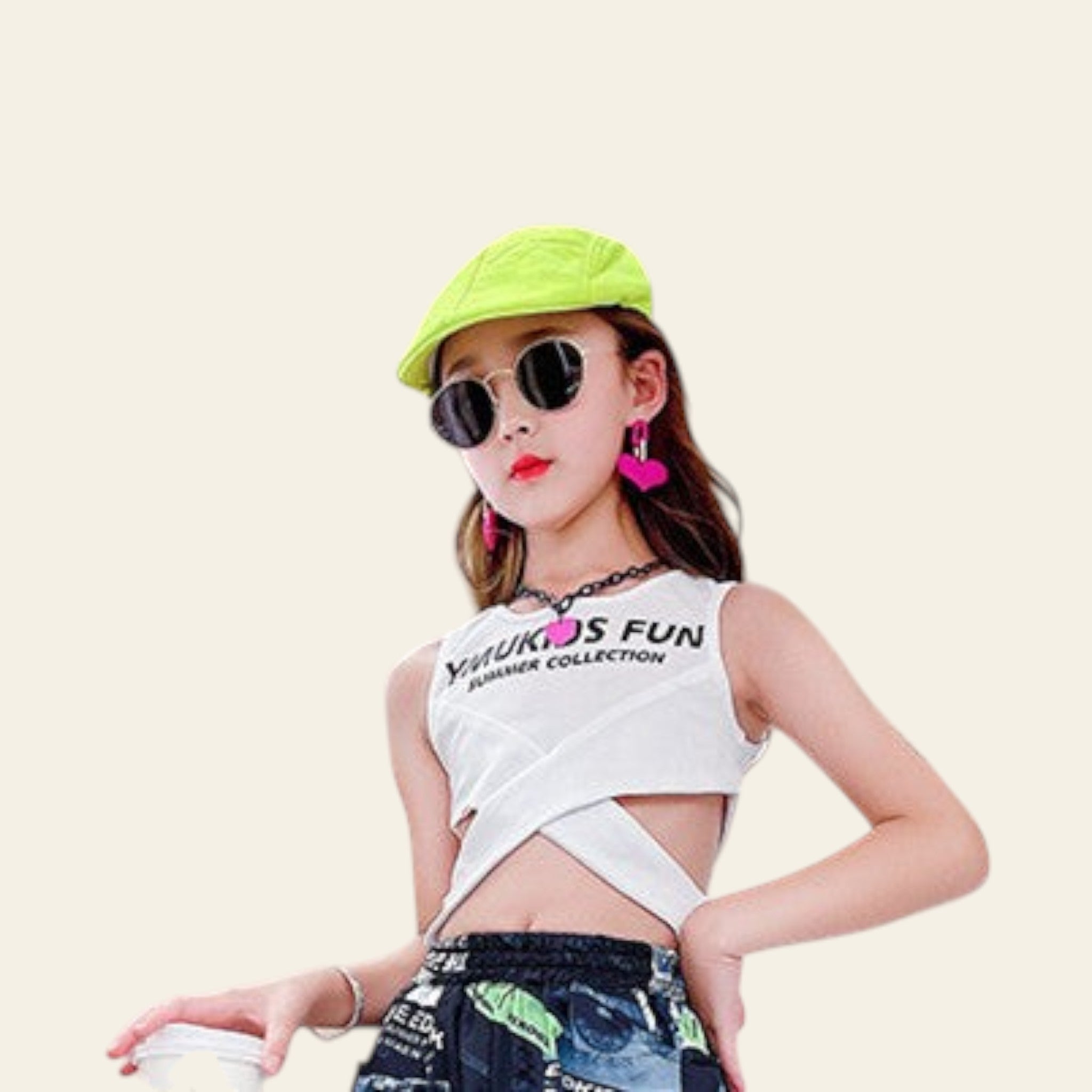 Woman wearing a white sleeveless top with text and colorful pants, standing against a neutral background.