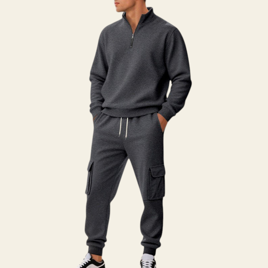 Man wearing a dark gray fleece-lined tracksuit set with zip-up jacket and jogger pants on a city street
