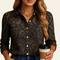 Person wearing a patterned shirt holding a coffee cup against a beige background