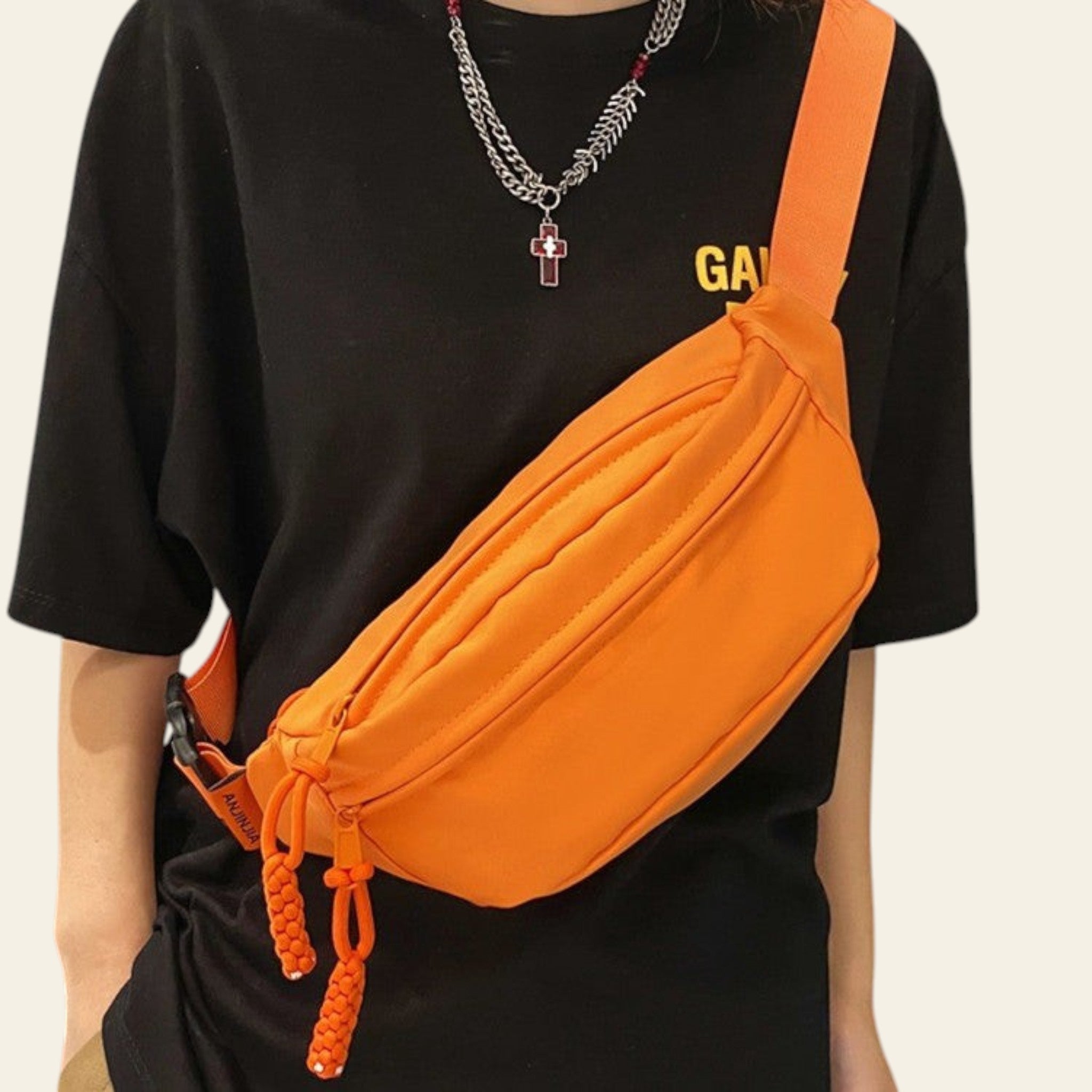 Person wearing an orange waist bag with a black t-shirt featuring yellow text.