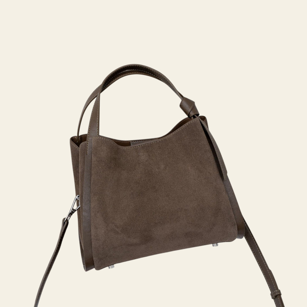 Brown handbag on a chair with a neutral background