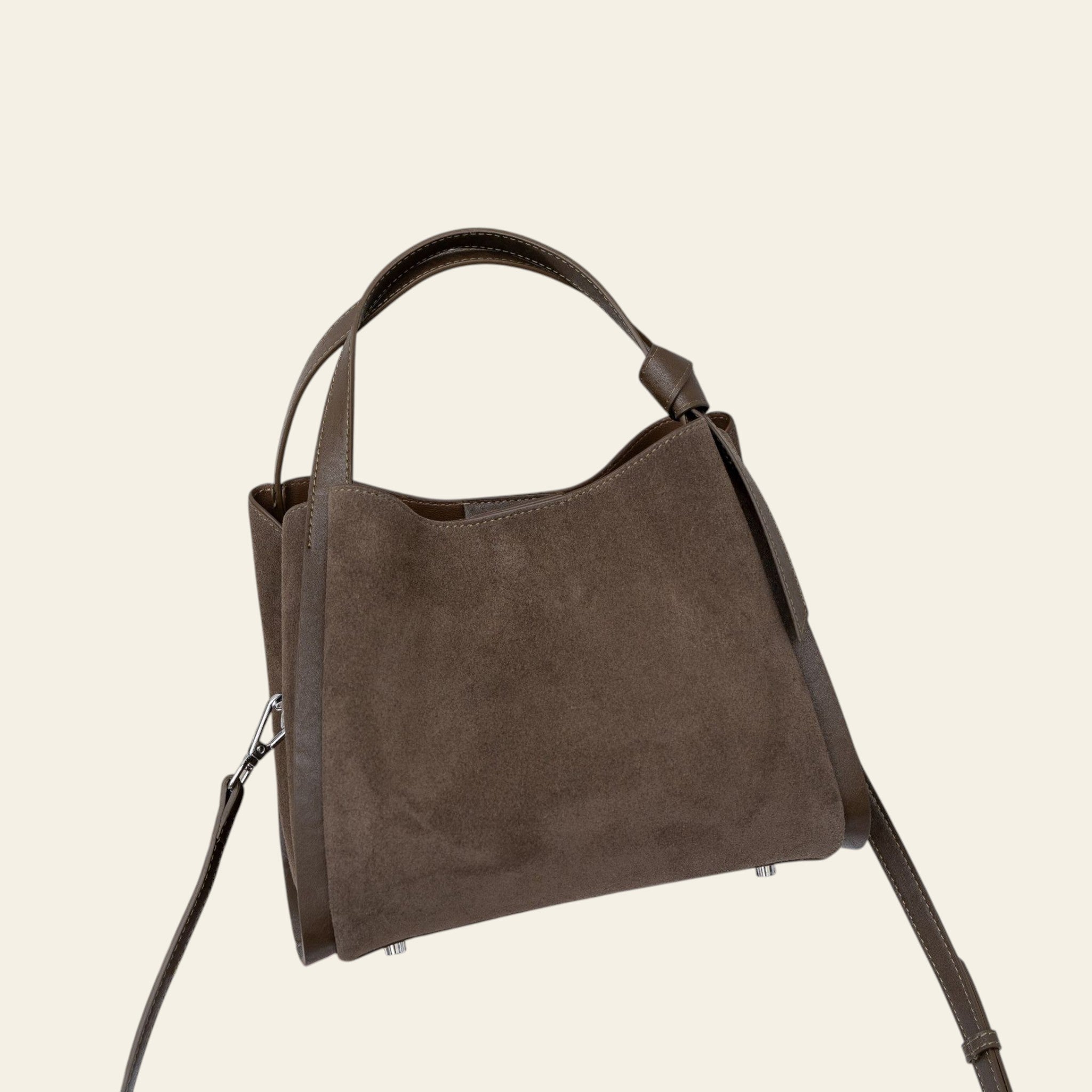 Brown handbag on a chair with a neutral background