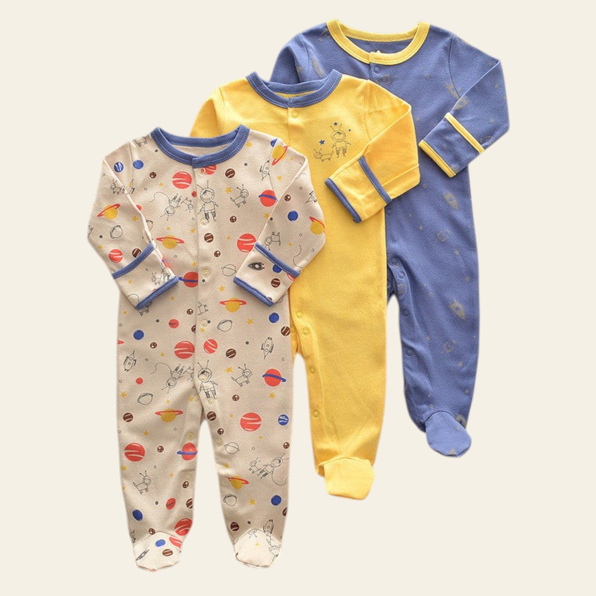 Three colorful baby onesies on a textured surface