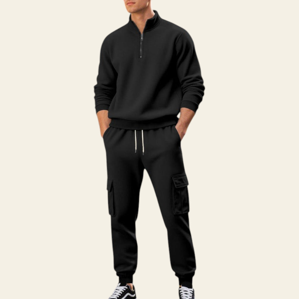 Man wearing a black fleece-lined tracksuit set with zip-up jacket and jogger pants on a city street