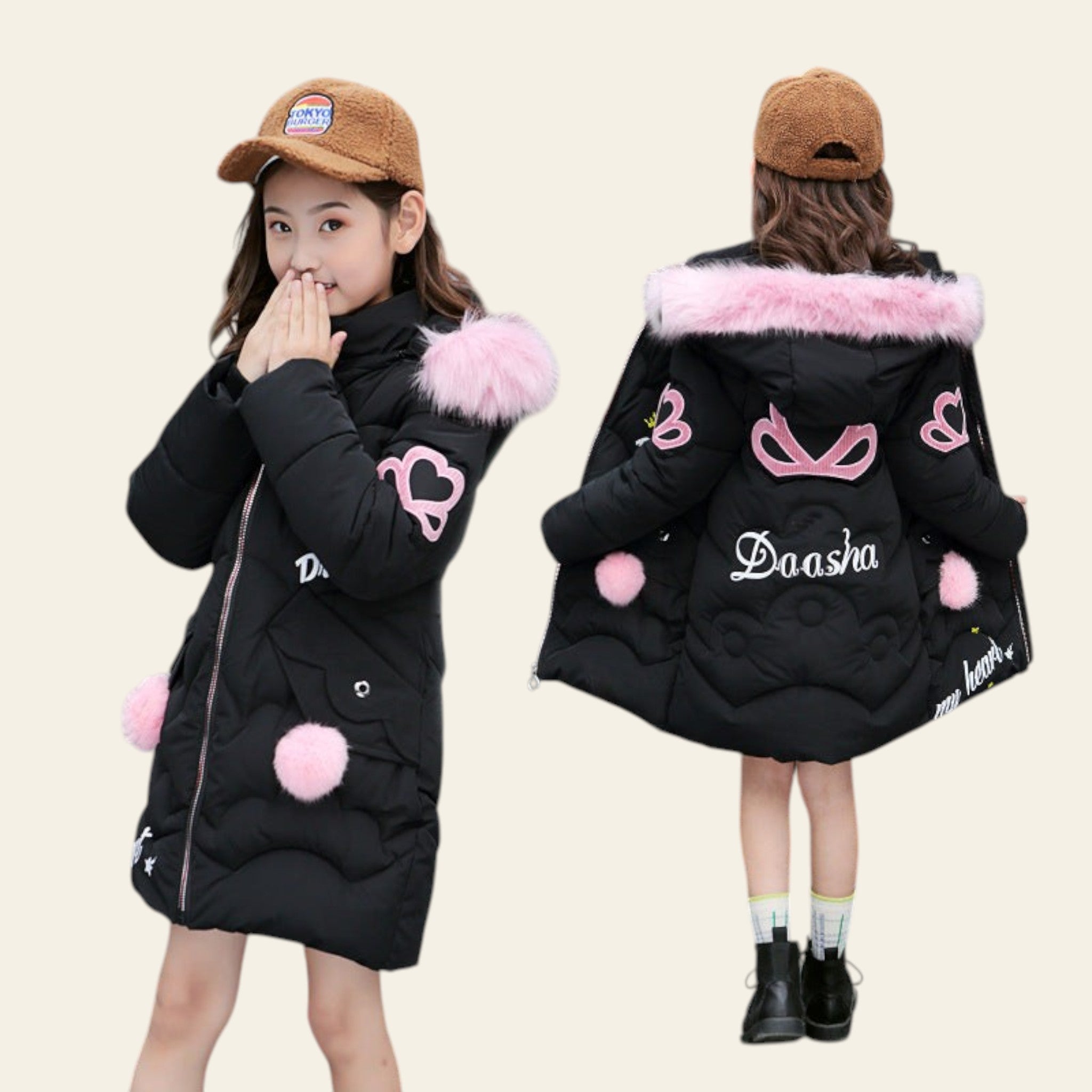 Two children wearing black winter coats with pink accents and fur-lined hoods, standing on a street.