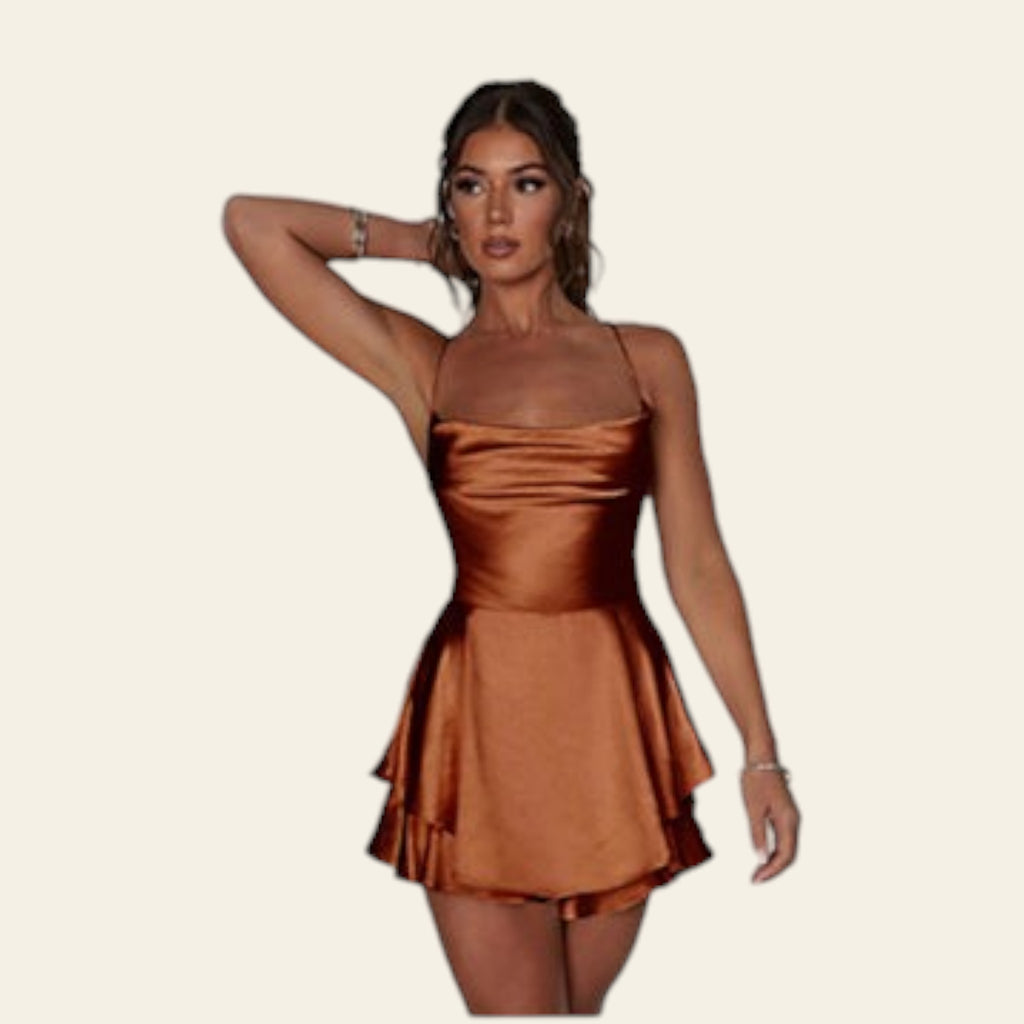 Woman wearing a bronze dress with a close-up of a silver bracelet on a white background