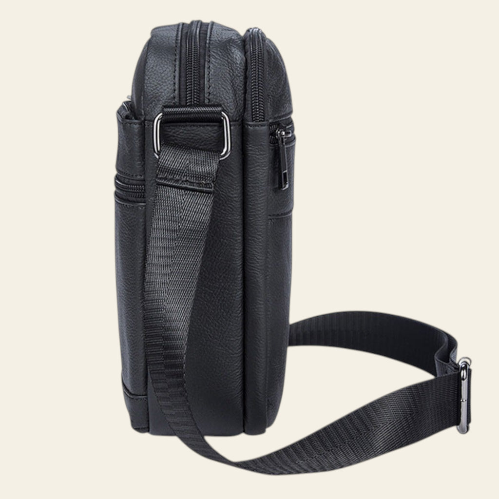 Black crossbody bag with a strap on a white background
