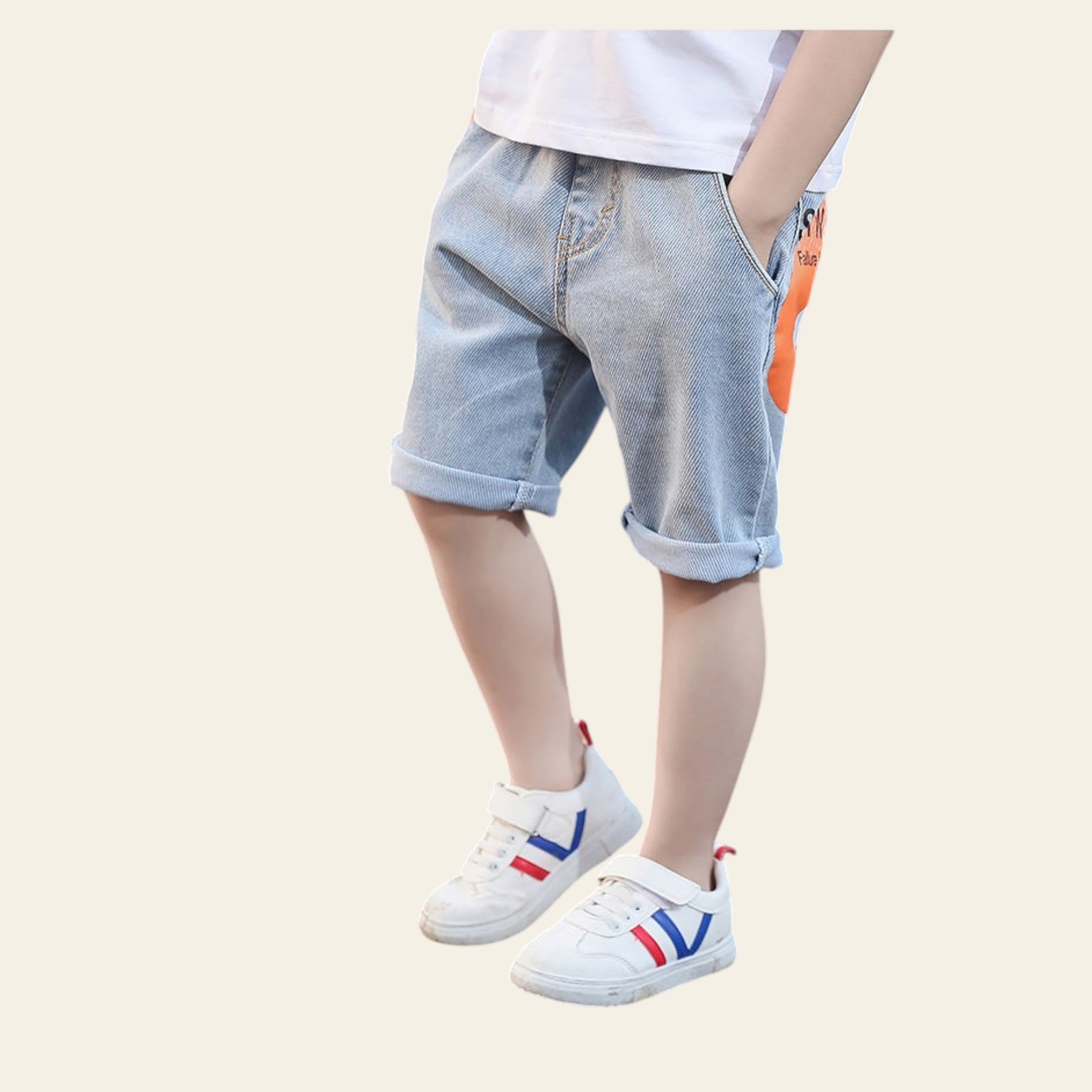 Child wearing light blue denim shorts and white sneakers on a road.