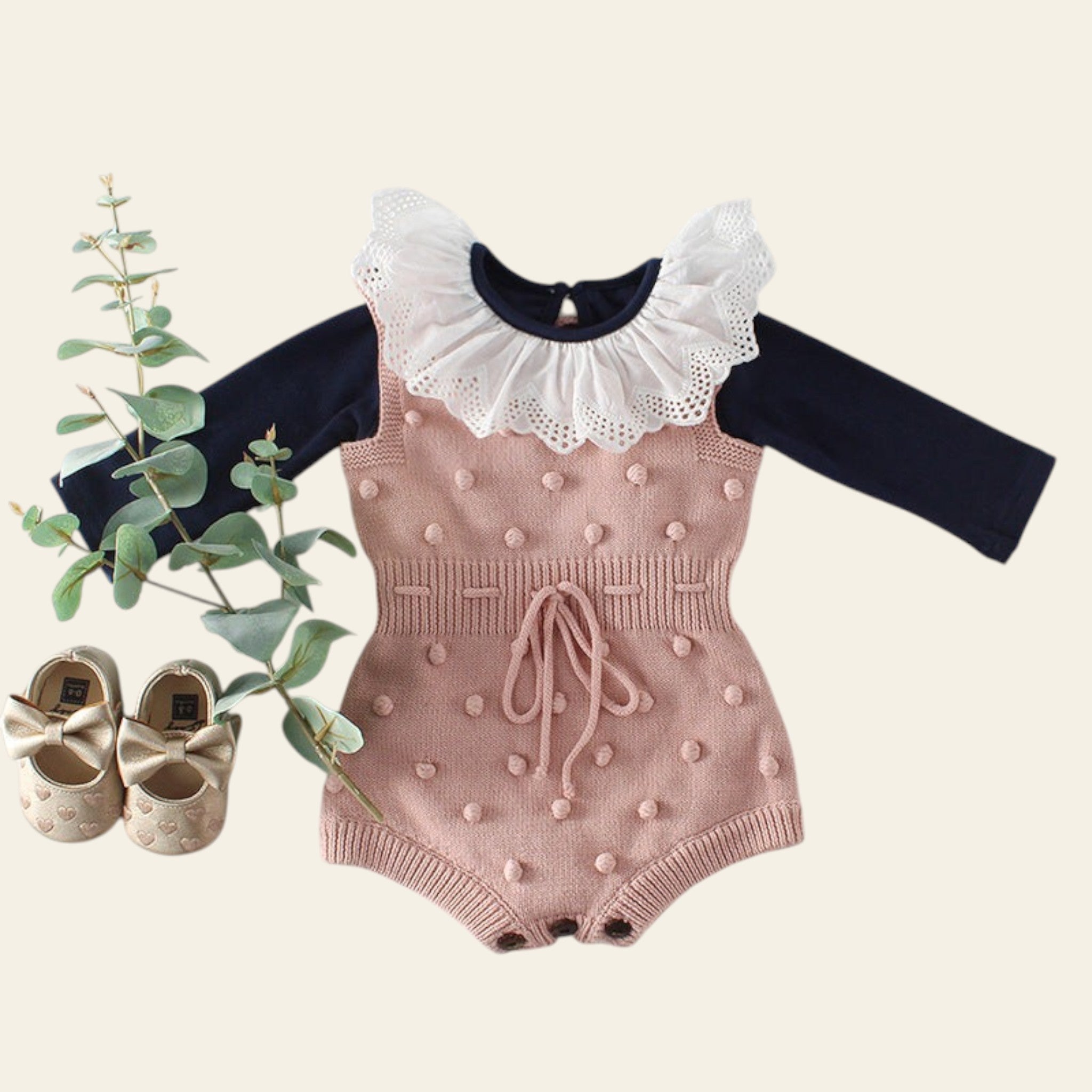 Pink baby romper with long-sleeve top on a light gray background