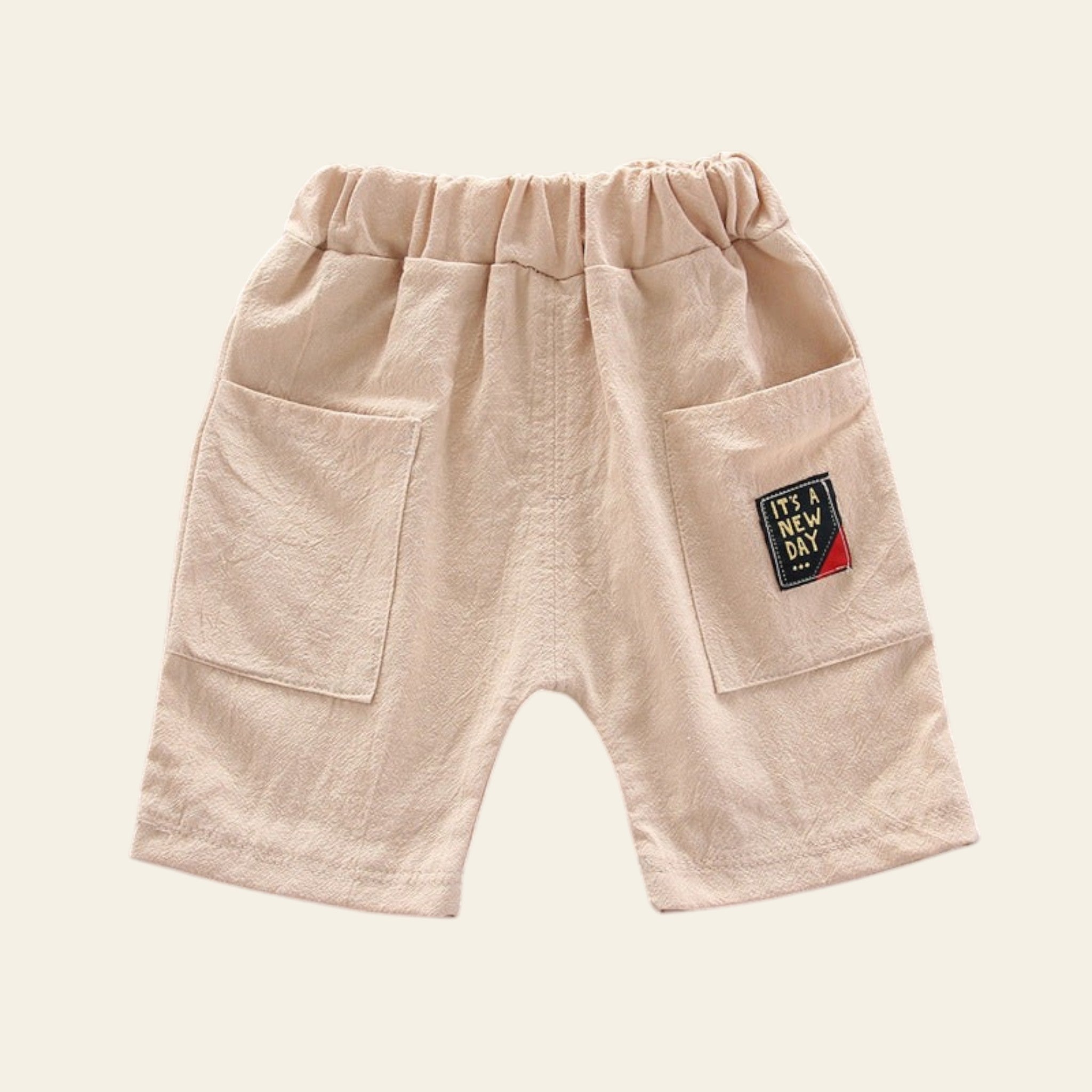 Beige shorts with a patch on a gray background
