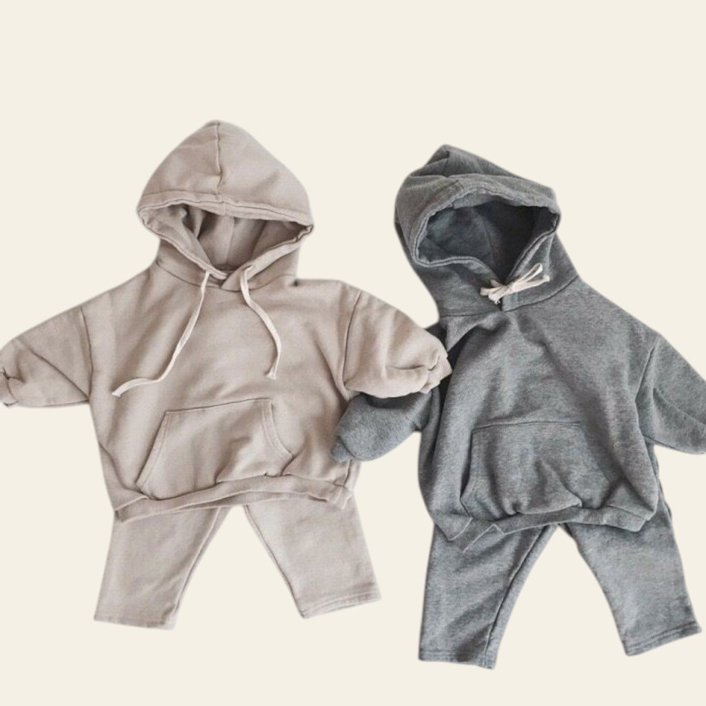 Two baby hoodies, one beige and one gray, on a white background
