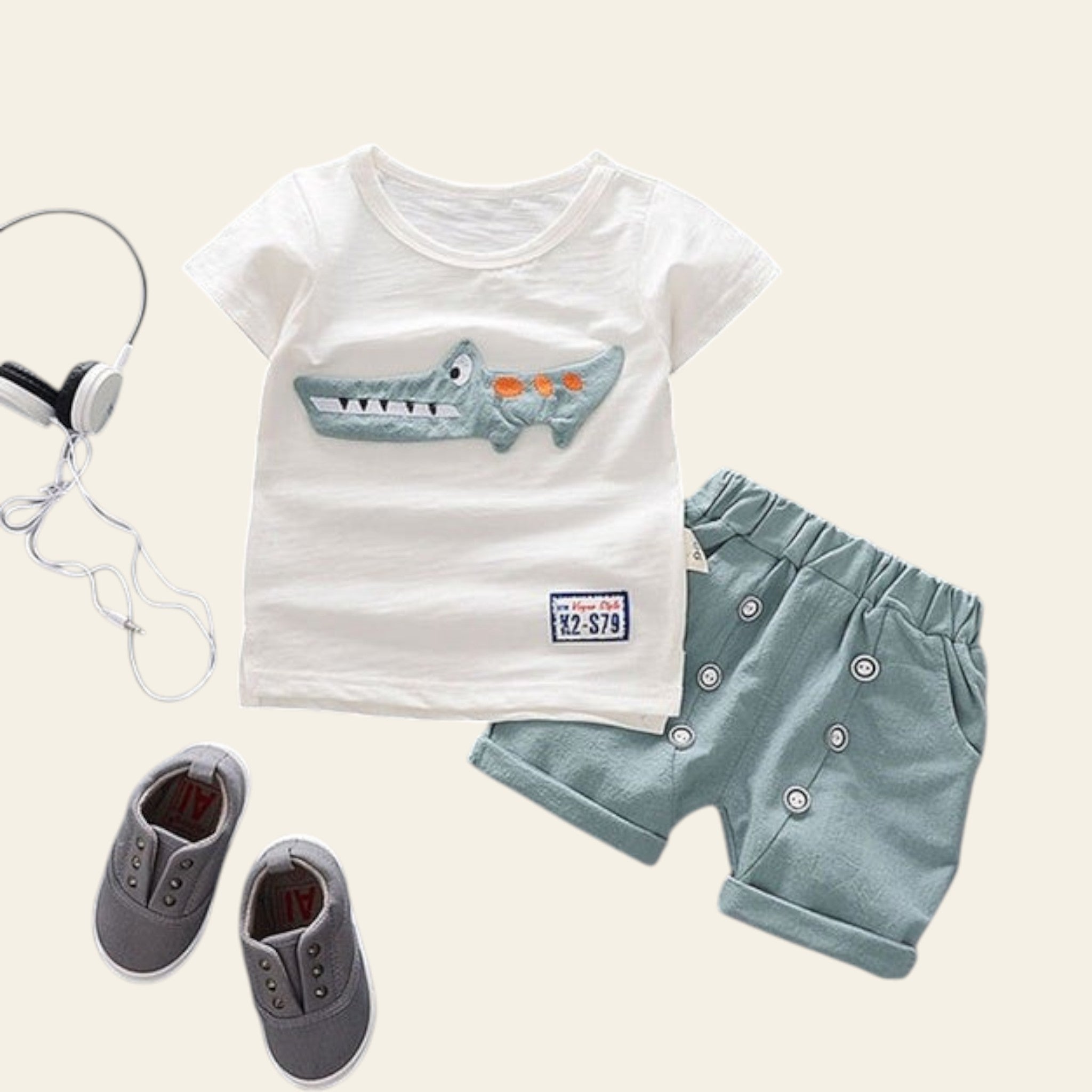 Children's outfit with white t-shirt and green shorts on a gray background