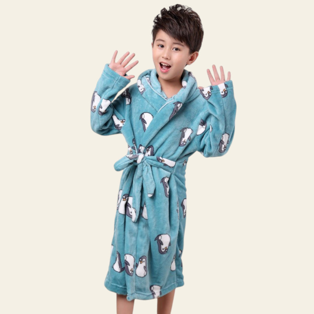 Child wearing a blue robe with animal patterns on a plain background