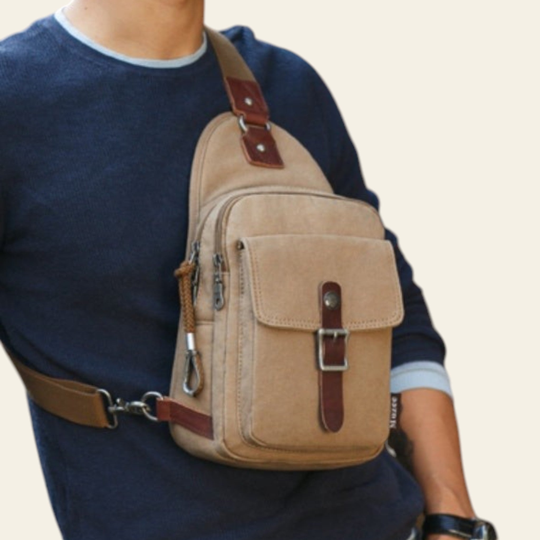 Person wearing a beige sling bag with brown leather straps.