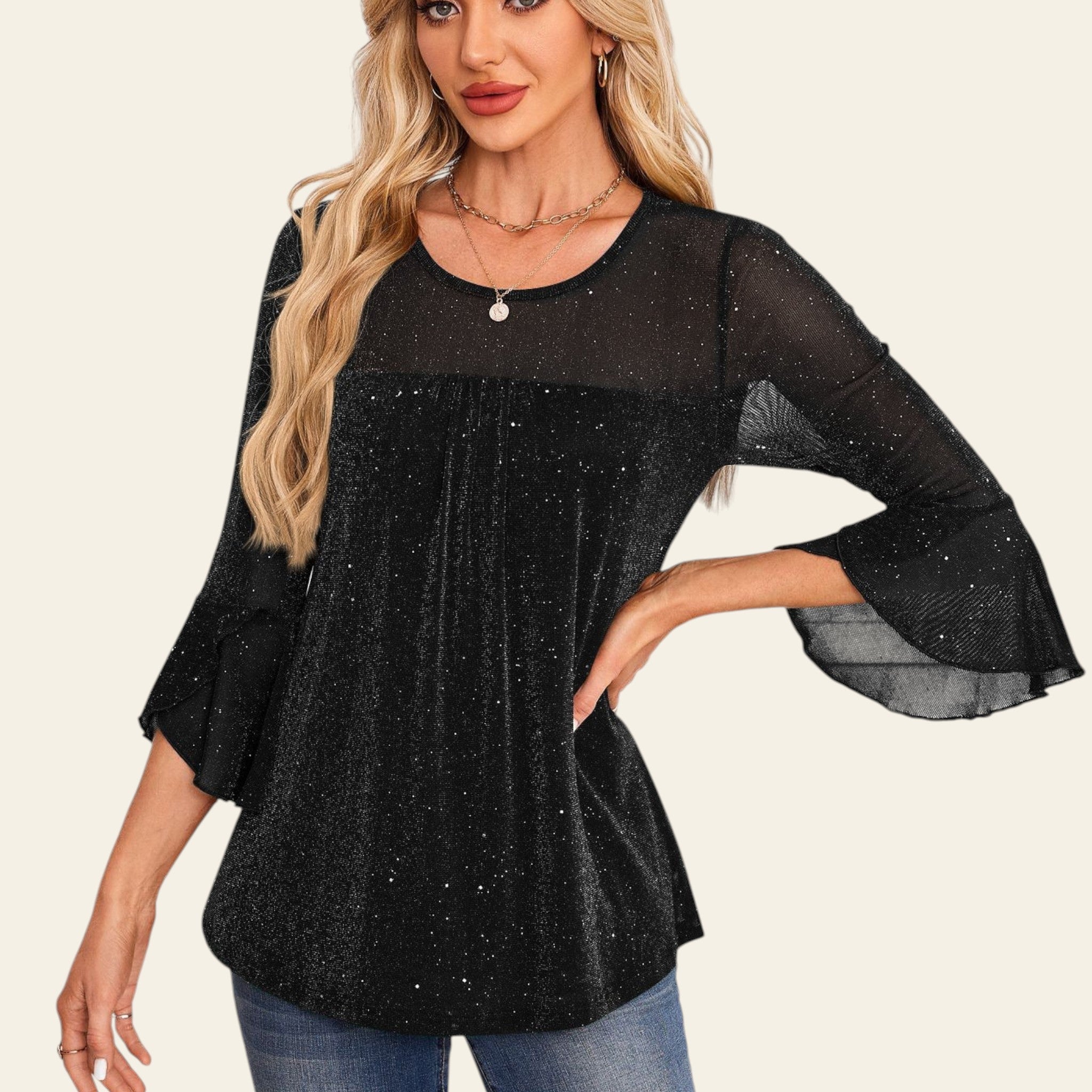 Woman wearing a black blouse with bell sleeves in an elegant interior setting