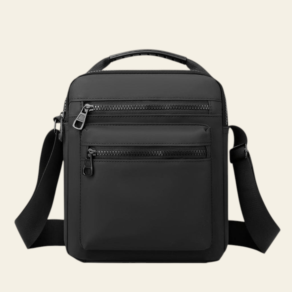 Black crossbody bag with zippers on a white background