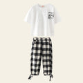 White t-shirt with graphic design and black and white checkered pants on a white background