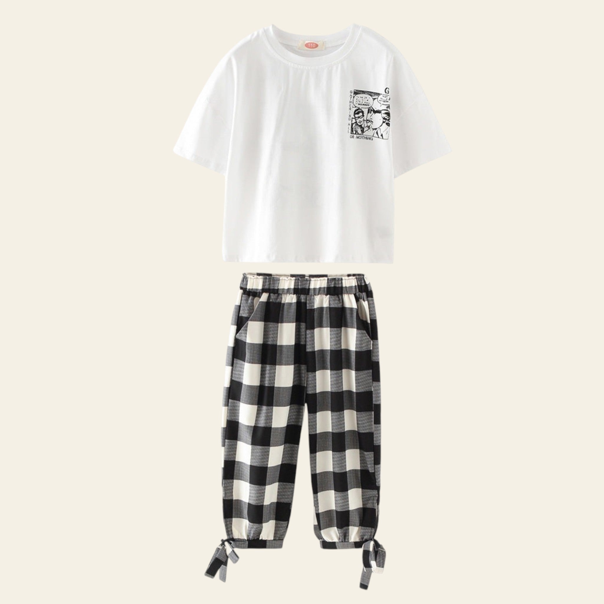 White t-shirt with graphic design and black and white checkered pants on a white background