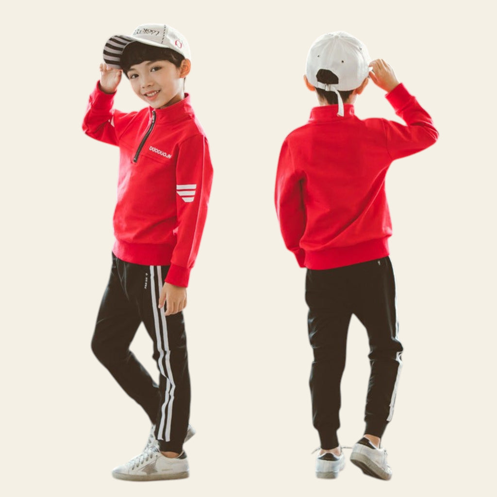 Child wearing a red jacket and black pants with white stripes, standing against a plain background.