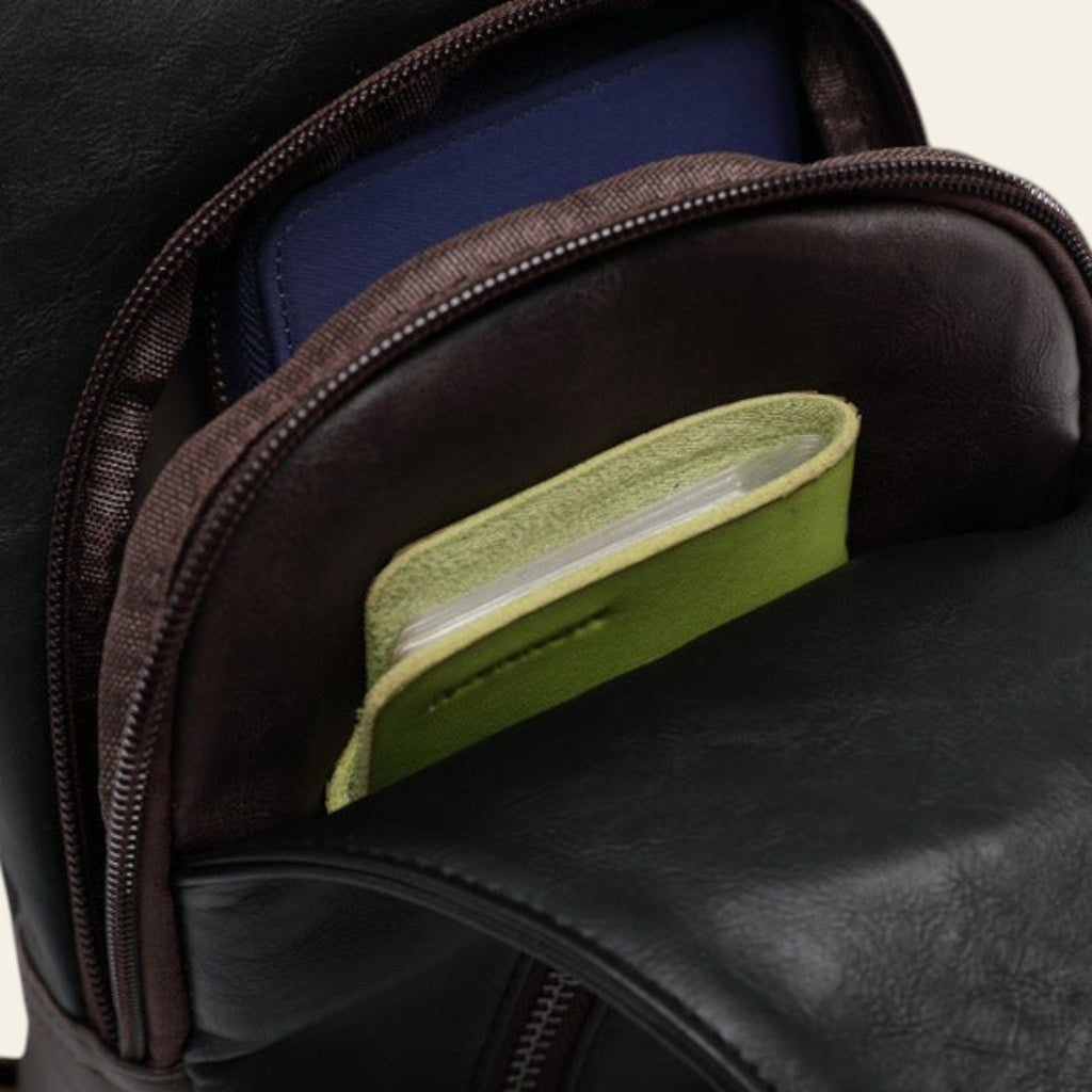 Close-up of a black leather bag with a green card holder inside.