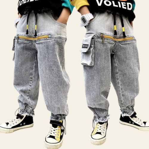 Two pairs of gray jogger pants worn by people, with a blurred indoor background.