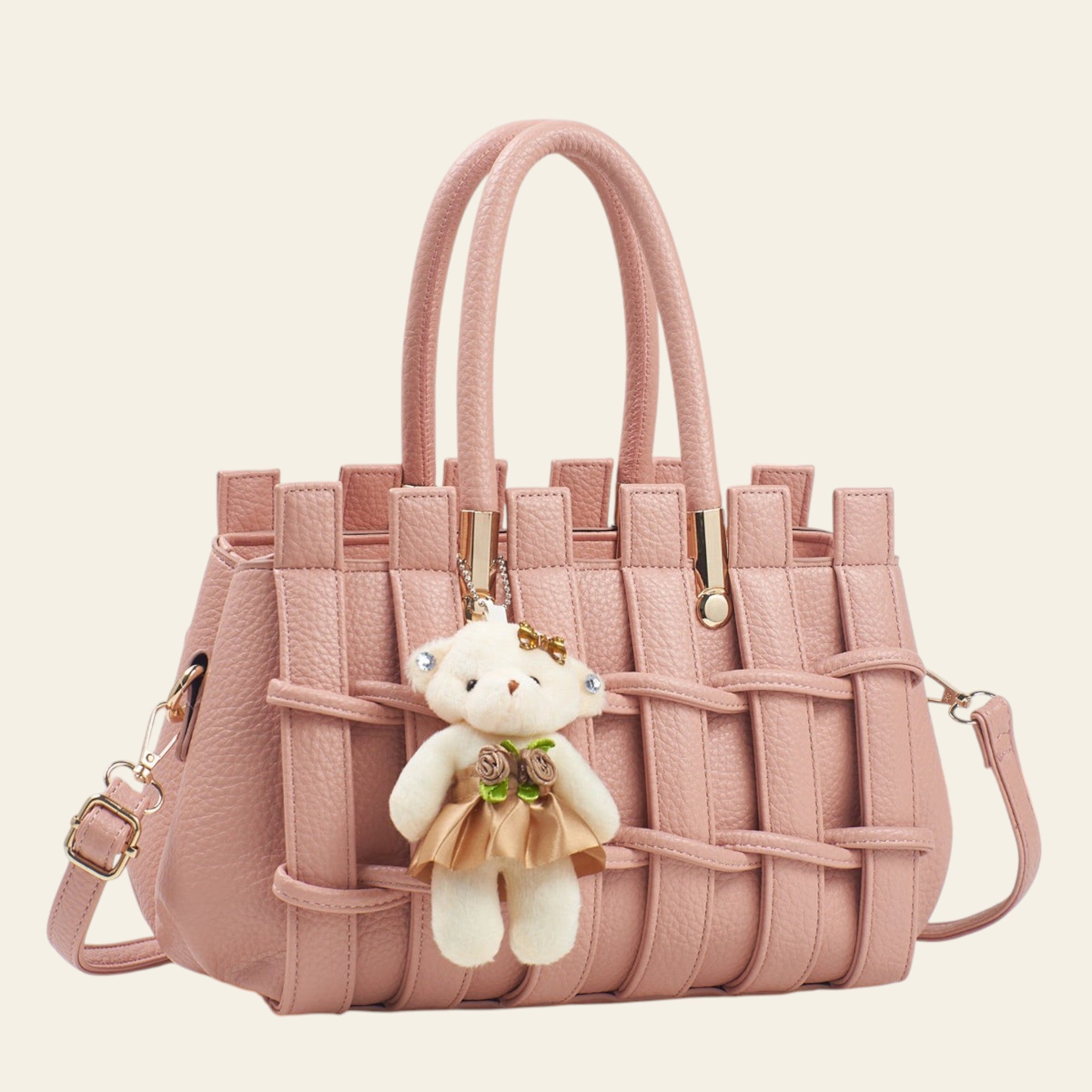 Pink woven handbag with a teddy bear keychain on a light background