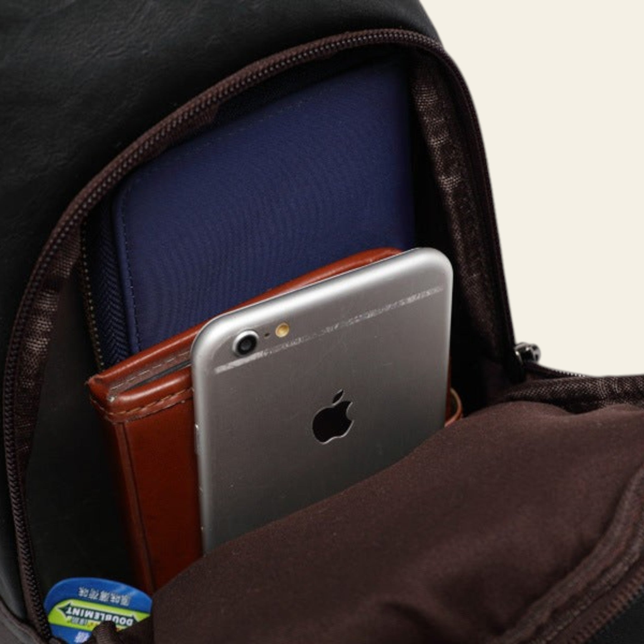 Smartphone in a pocket of a black backpack with a visible brand label.