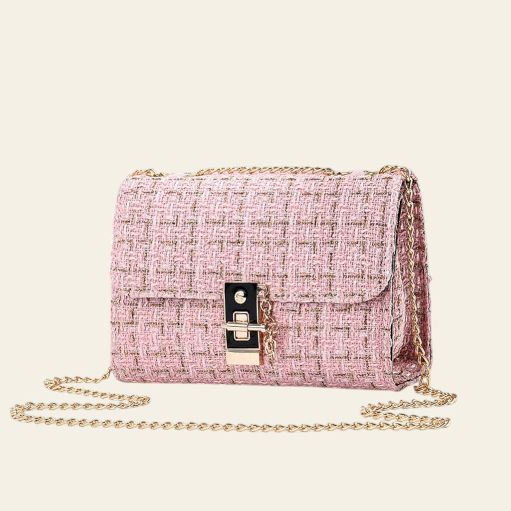 Pink textured handbag with gold chain on a light gray background