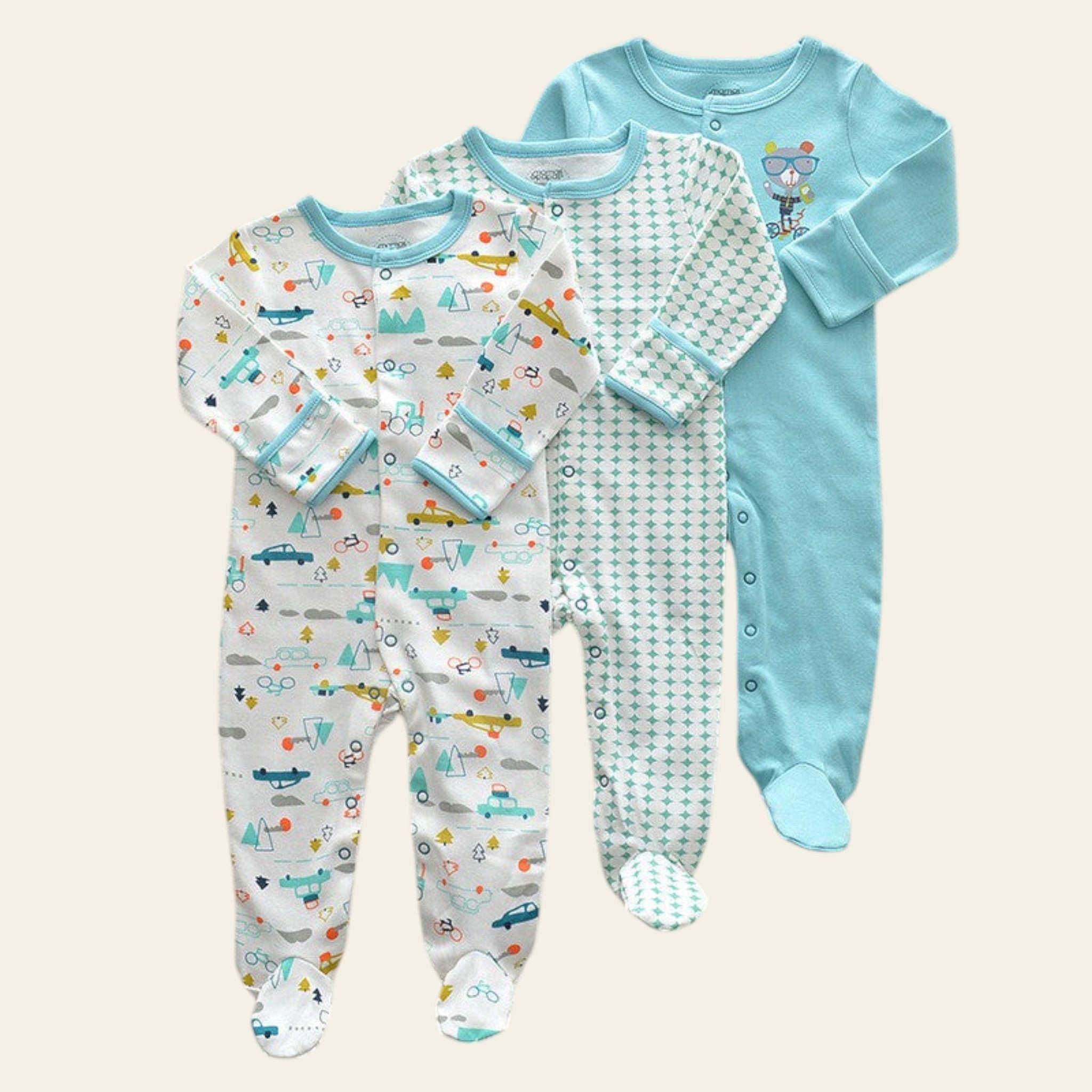 Three baby onesies with different patterns on a beige surface