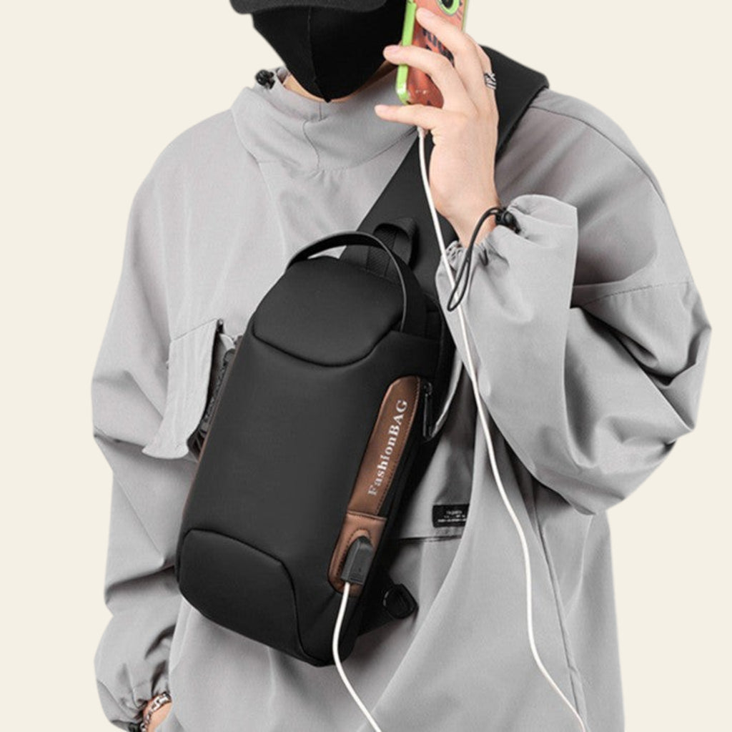 Person wearing a gray jacket with a black backpack, holding a phone.