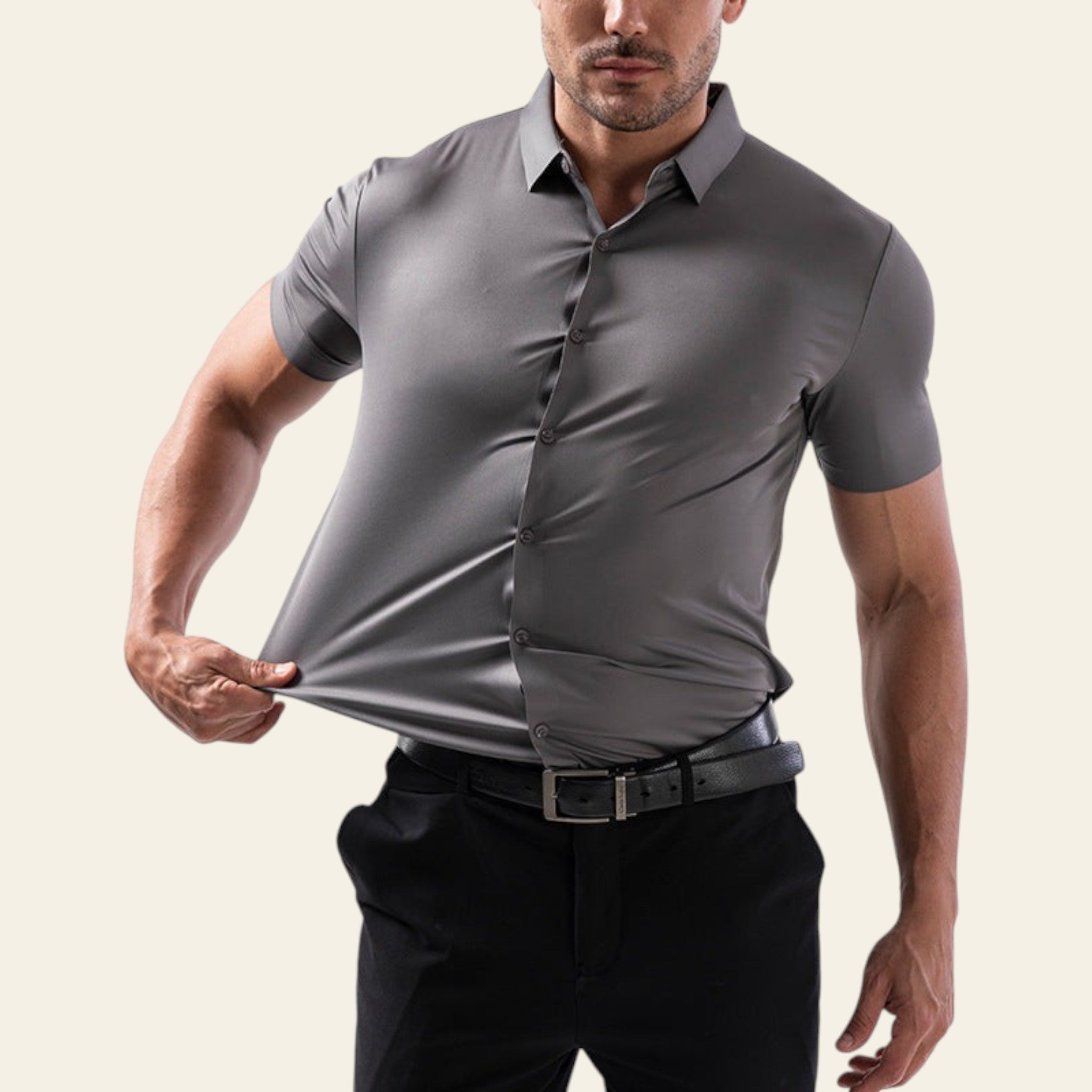 Man wearing a gray short-sleeve dress shirt and black pants on a light gray background