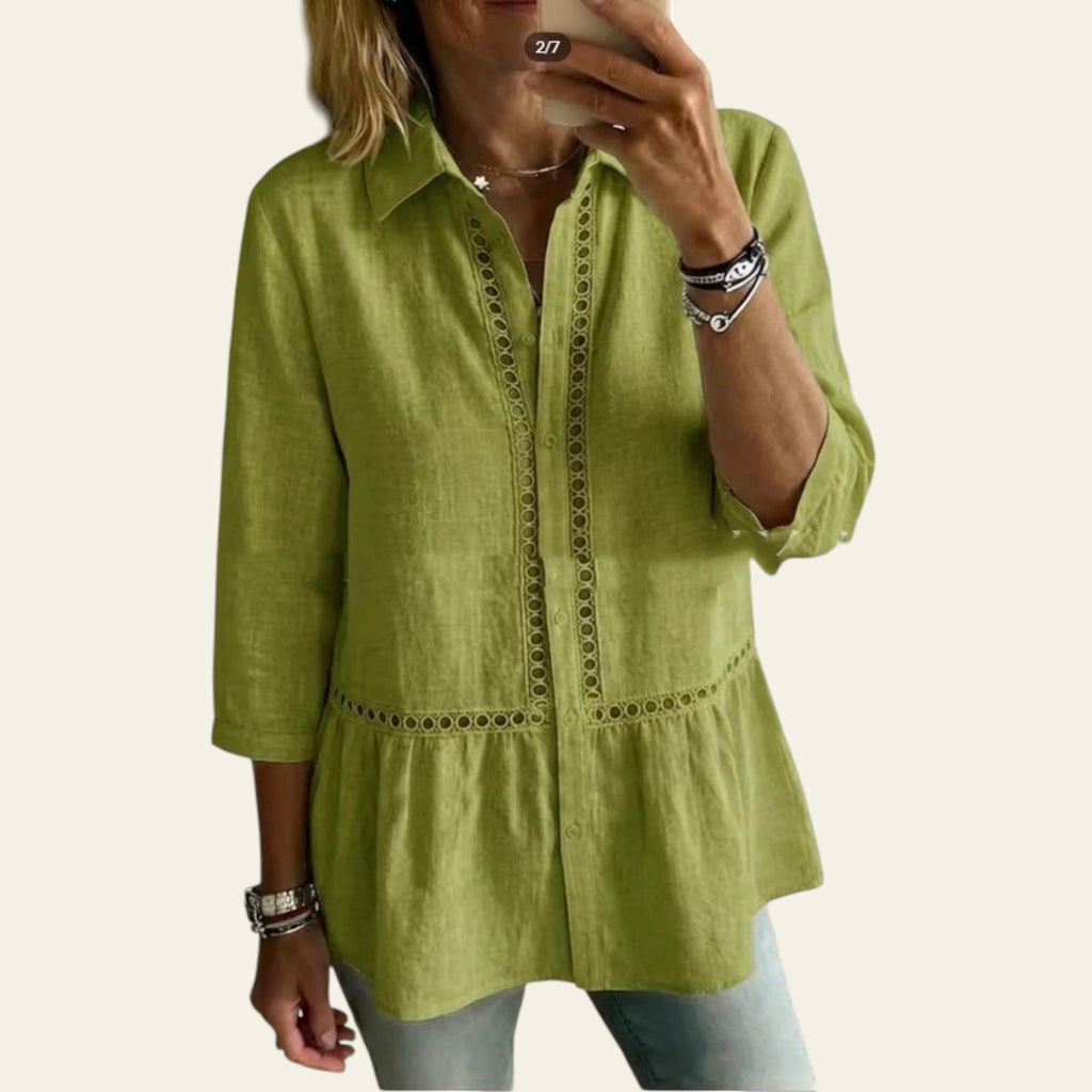 Person wearing a green shirt taking a mirror selfie in a room with a couch and plant.